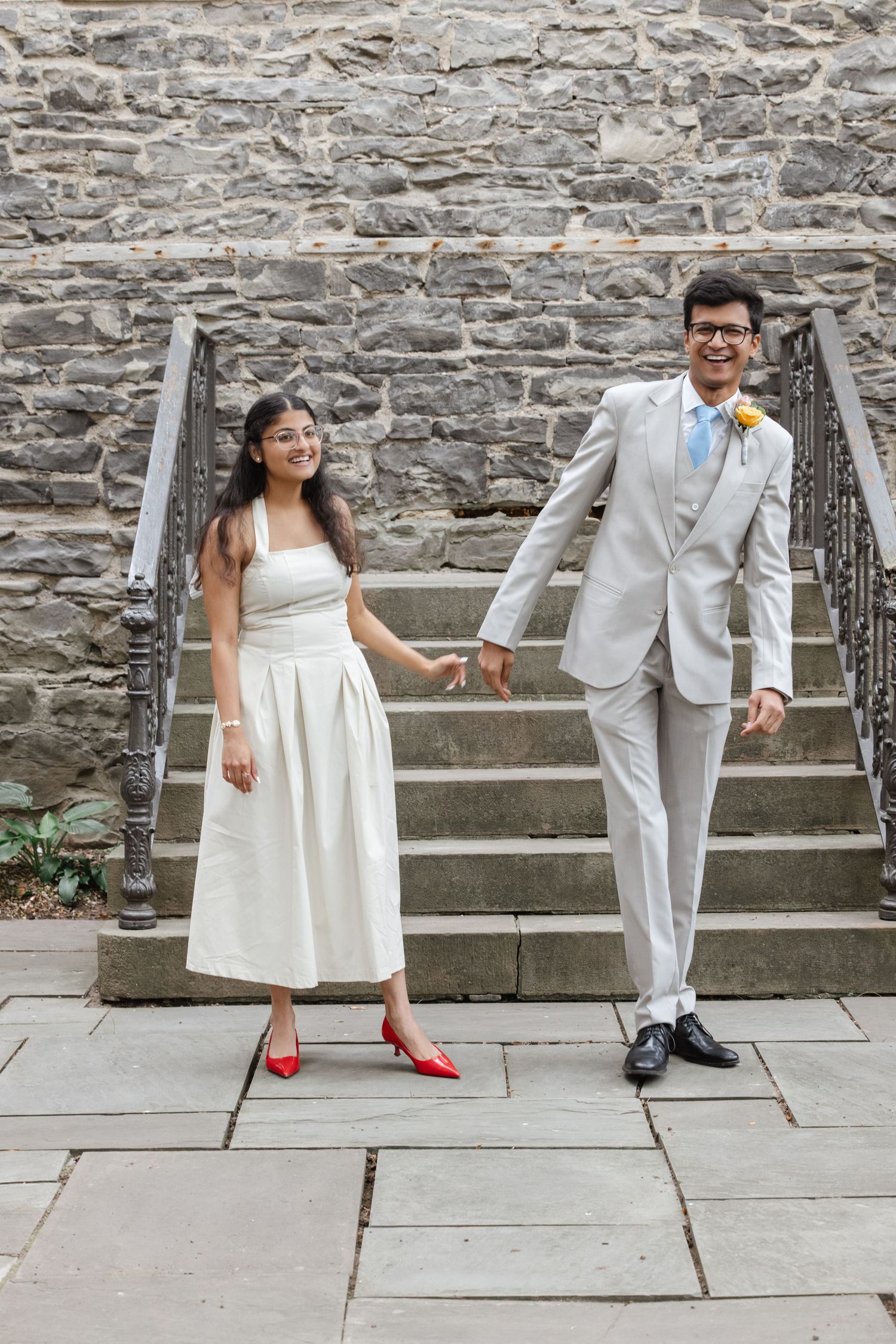 Couple in formal attire posing on stone steps during wedding.  St. Josephs park wedding photographer