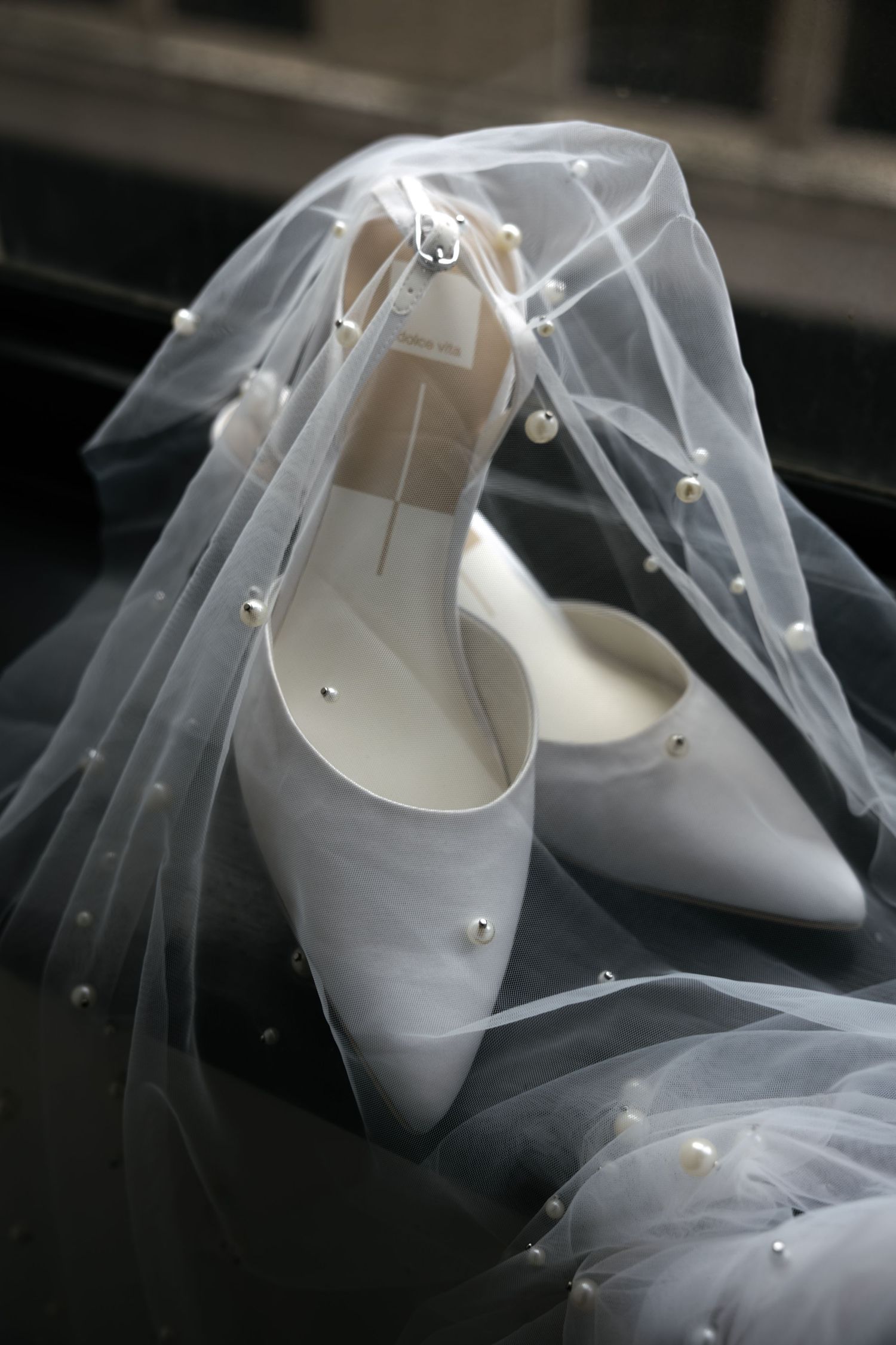 White bridal shoes wrapped in delicate tulle veil material.