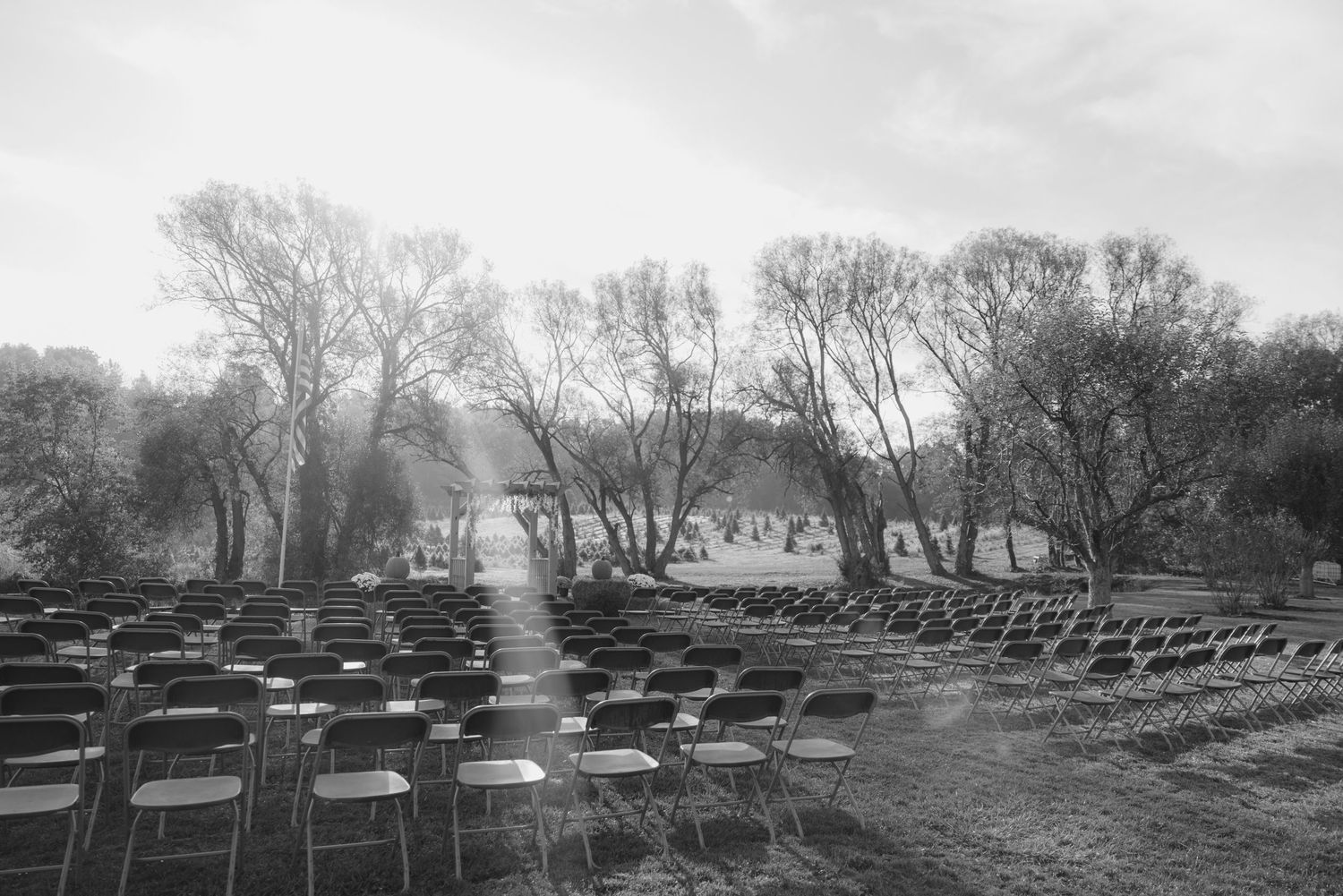 A black and white landscape of rows of chairs set up for an outdoor ceremony. wedding photographer Syracuse