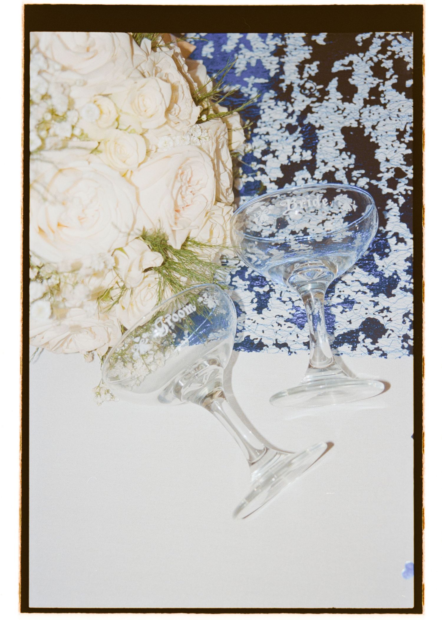 Wedding cake detail showing delicate white and blue floral decorations. Film wedding photographer NY