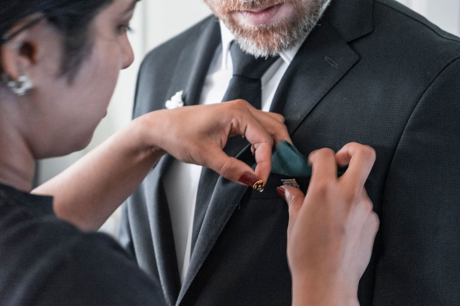 Close-up shots of someone adjusting a formal suit and tie. Ithaca outdoor wedding photographer