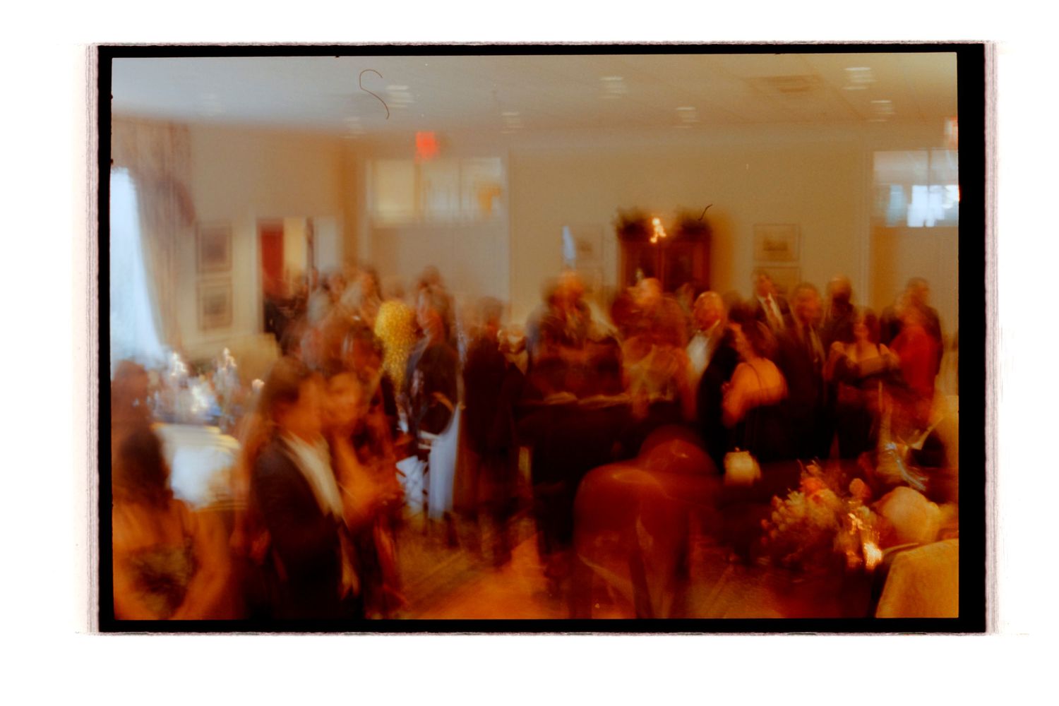 Warm-toned reception venue filled with dancing wedding guests. Rochester NY Film wedding photography