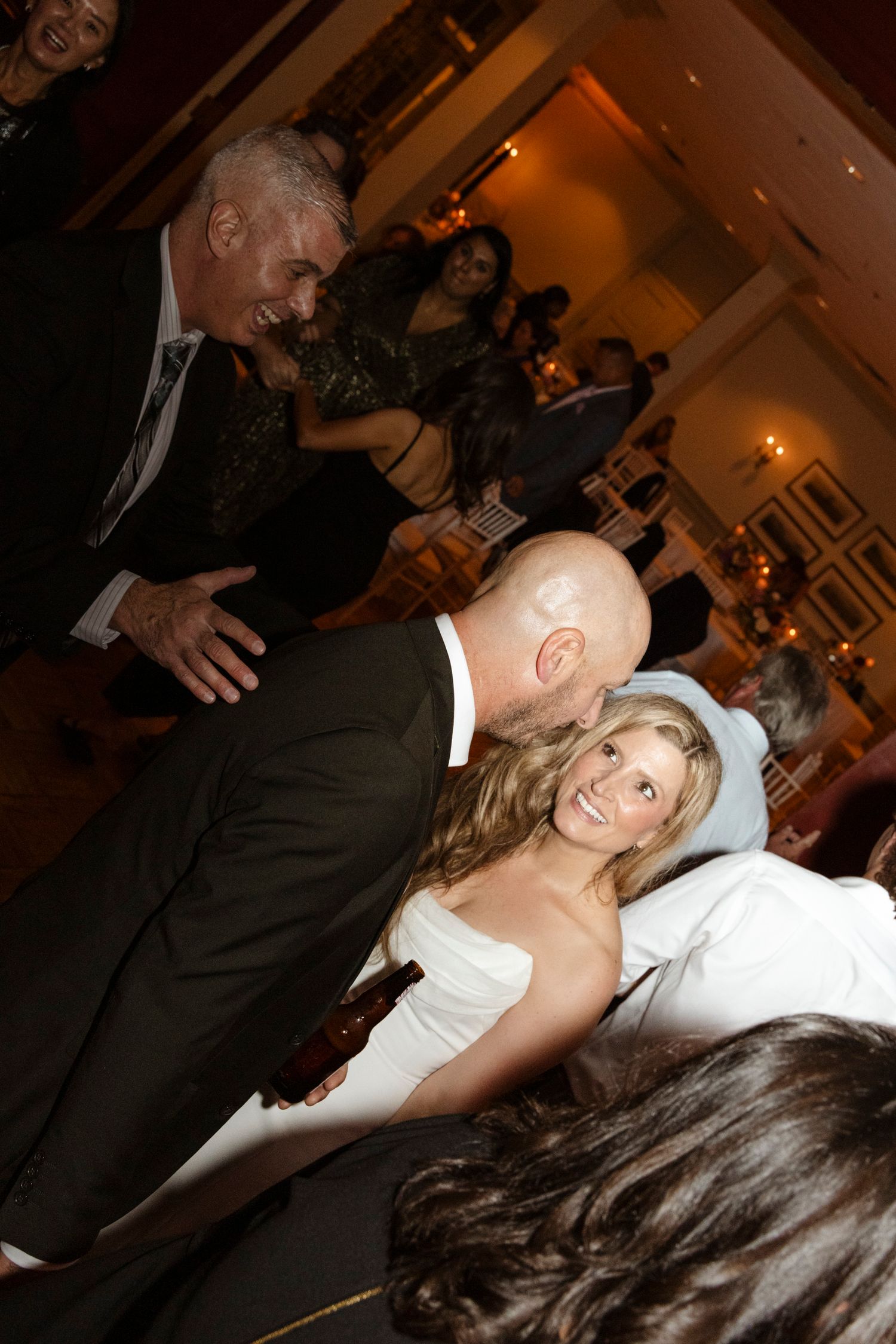 Wedding reception guests dancing and dipping on a crowded dance floor. Rochester NY candid wedding photography