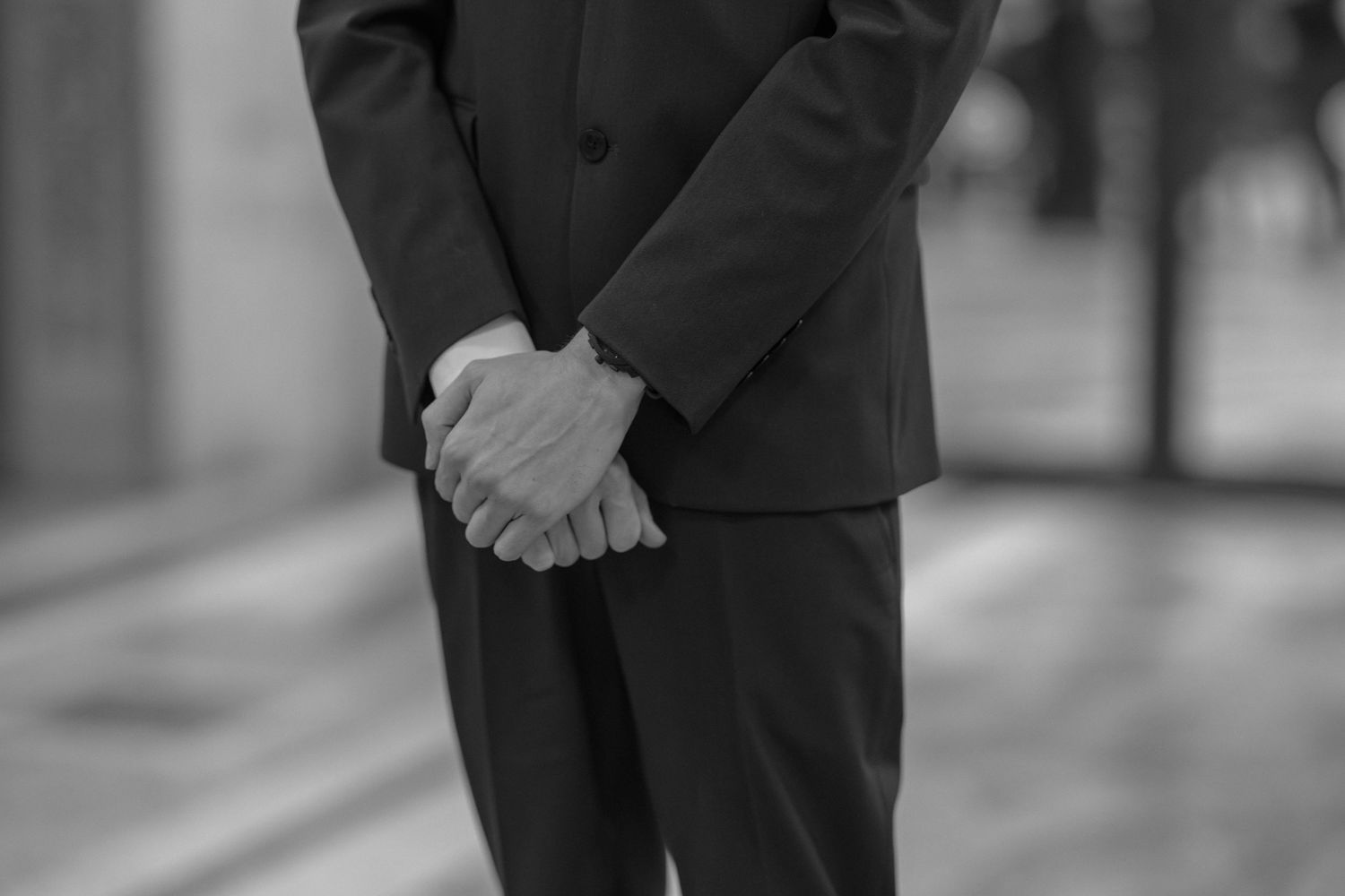 A black and white photo series showing a person in formal attire walking and posing on a city street.