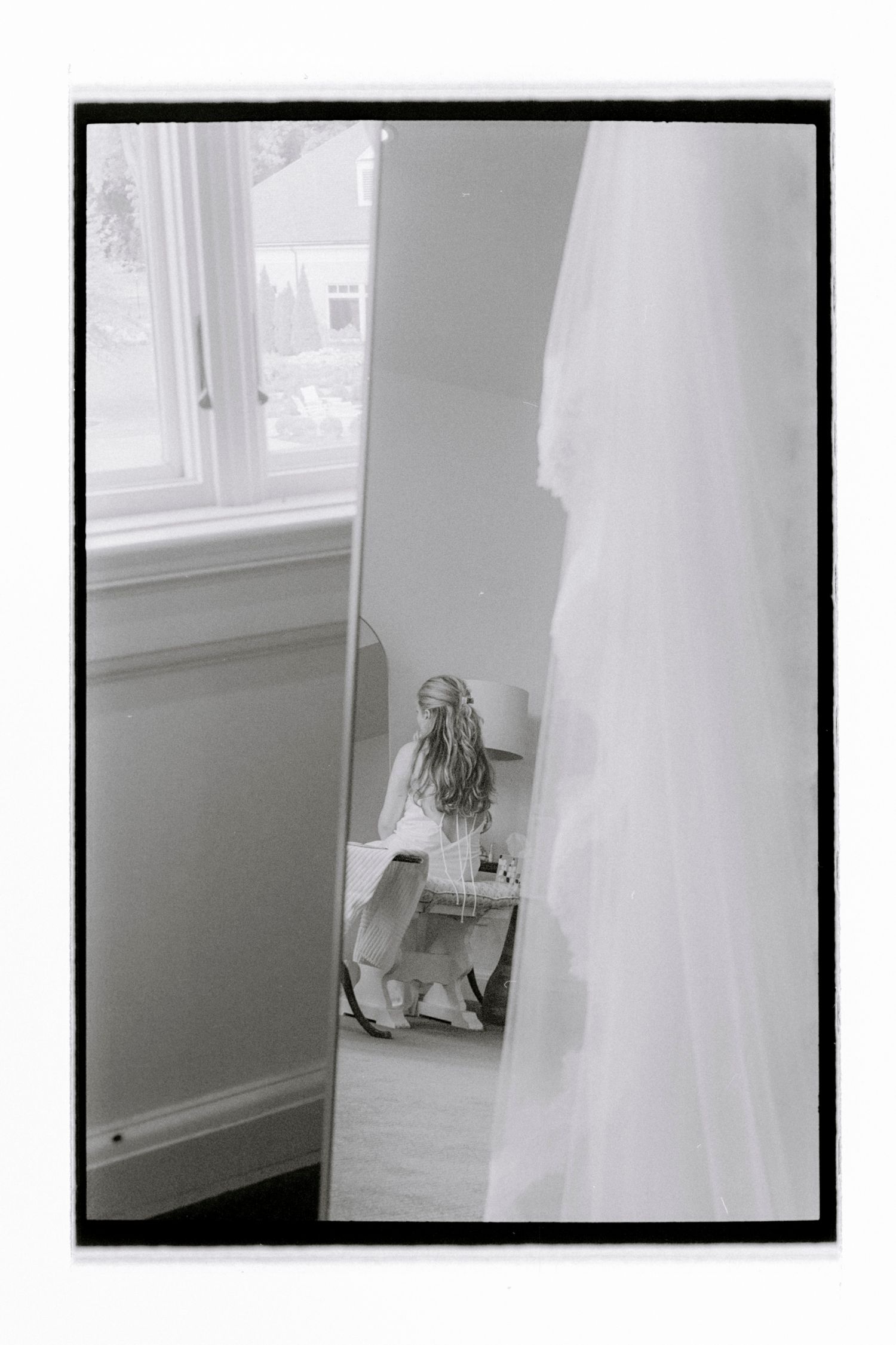 Wedding dress and accessories displayed near a bright window in a getting ready room. Rochester NY Film wedding photography