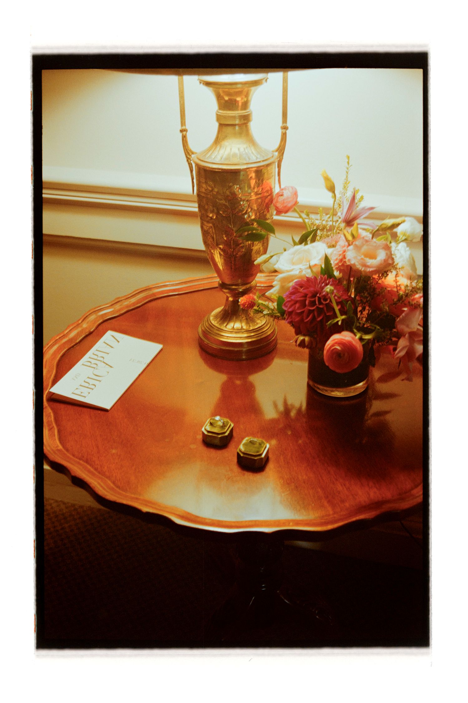 Elegant table setting with candelabra and floral centerpiece on a red-toned surface. Rochester NY Film wedding photography