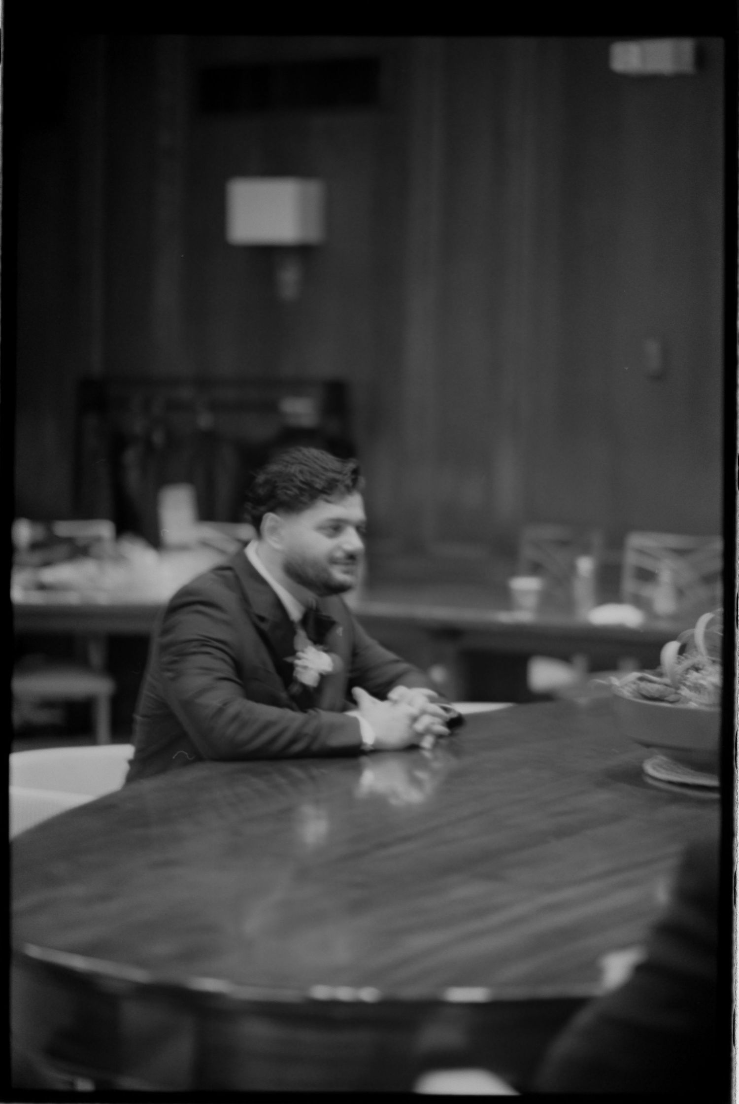 Black and white portrait of a guest seated at a reception table.