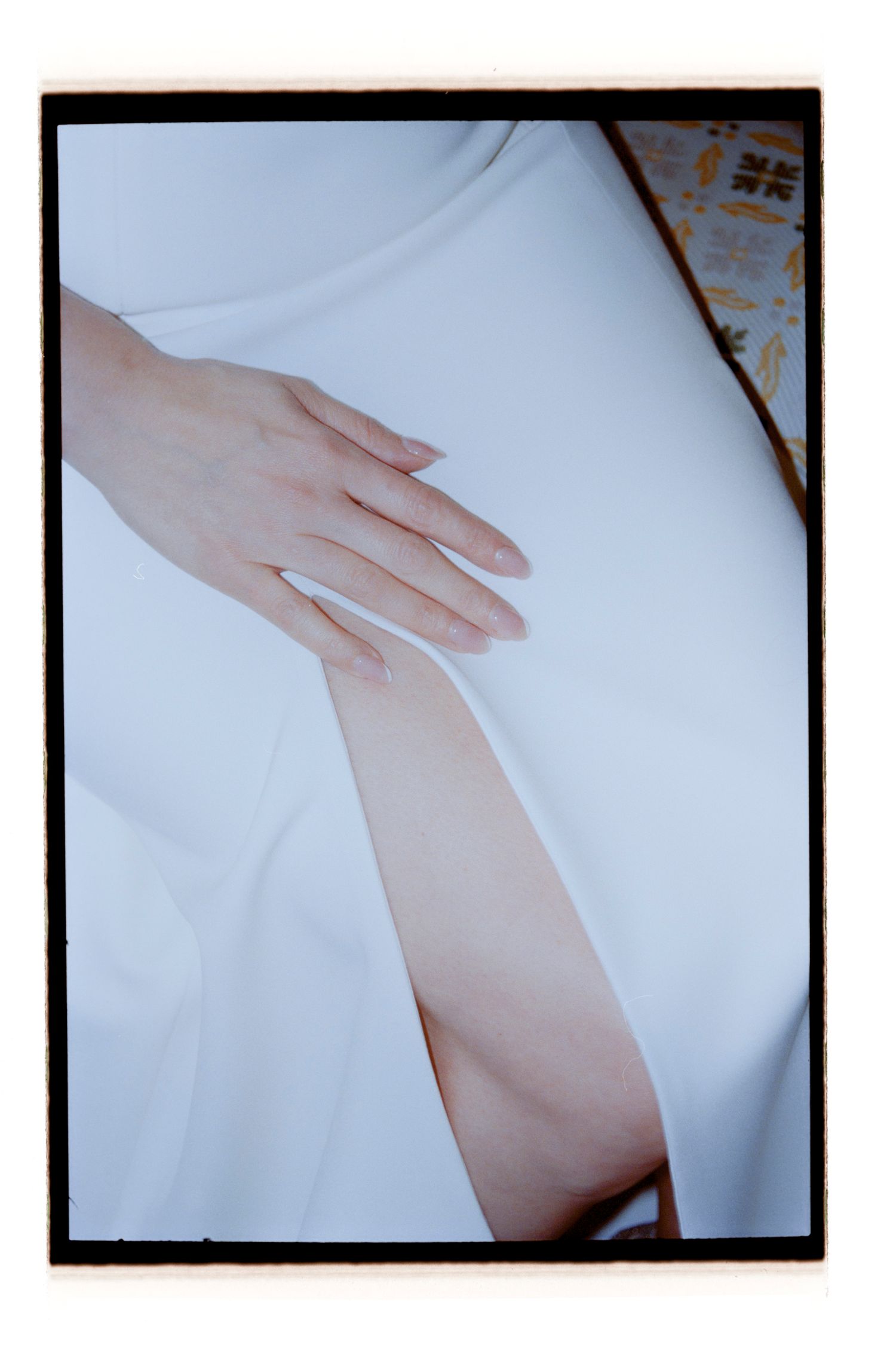 Close-up detail shot of hands resting on white wedding dress fabric. Rochester NY Film wedding photography