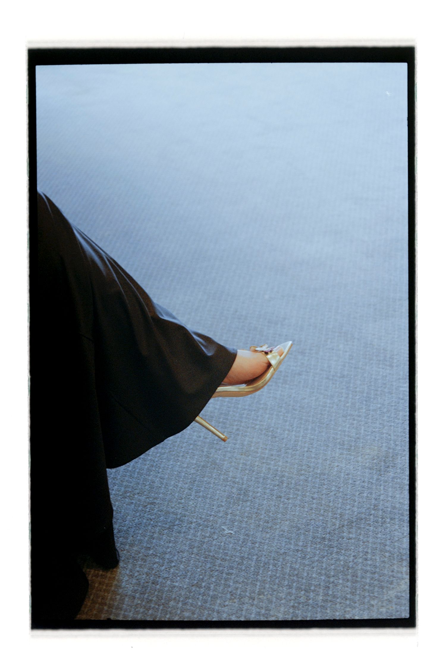Close-up of formal black shoe against blue carpeted floor. Rochester NY Film wedding photography