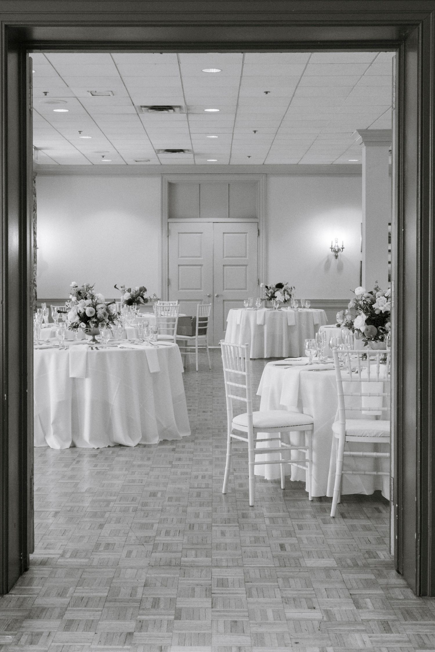 Clean white wedding reception venue with round tables and chiavari chairs.Rochester NY documentary wedding photography