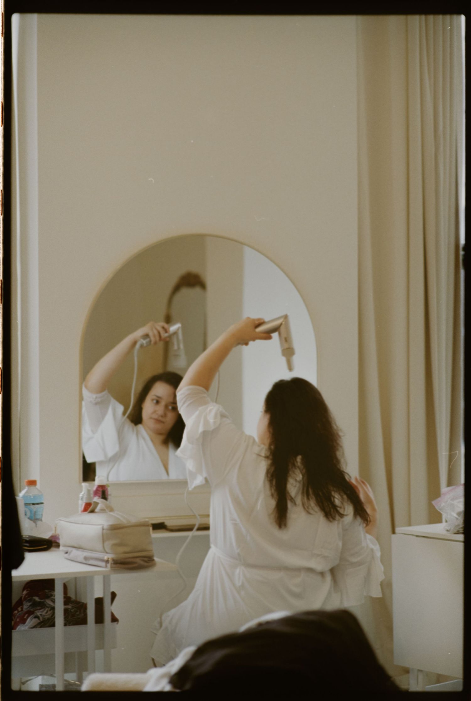 Artistic sequence of a person in white moving gracefully in a bright room with arched windows.