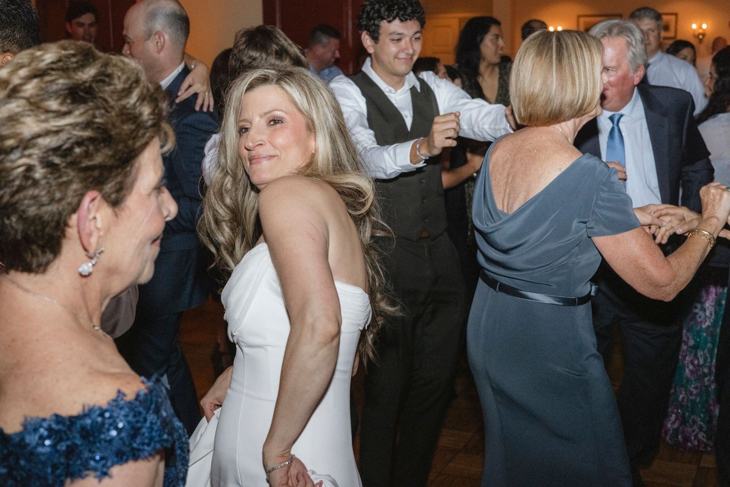 Lively party scene with multiple couples dancing together. Rochester NY documentary wedding photography
