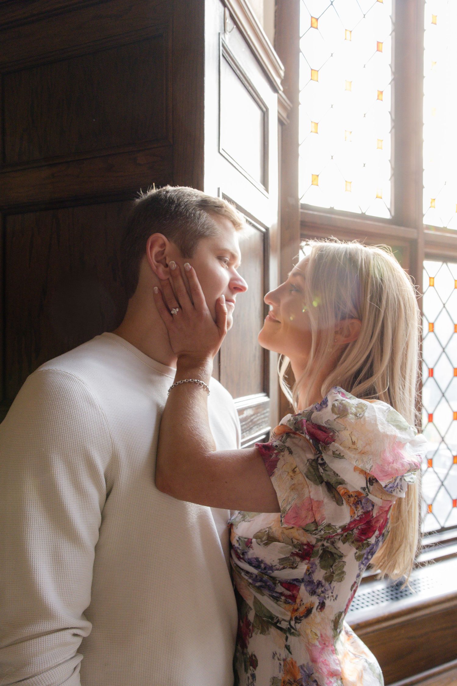 Romantic moment captured near ornate stained glass windows in warm natural lighting. Film wedding photographer Rochester  NY
