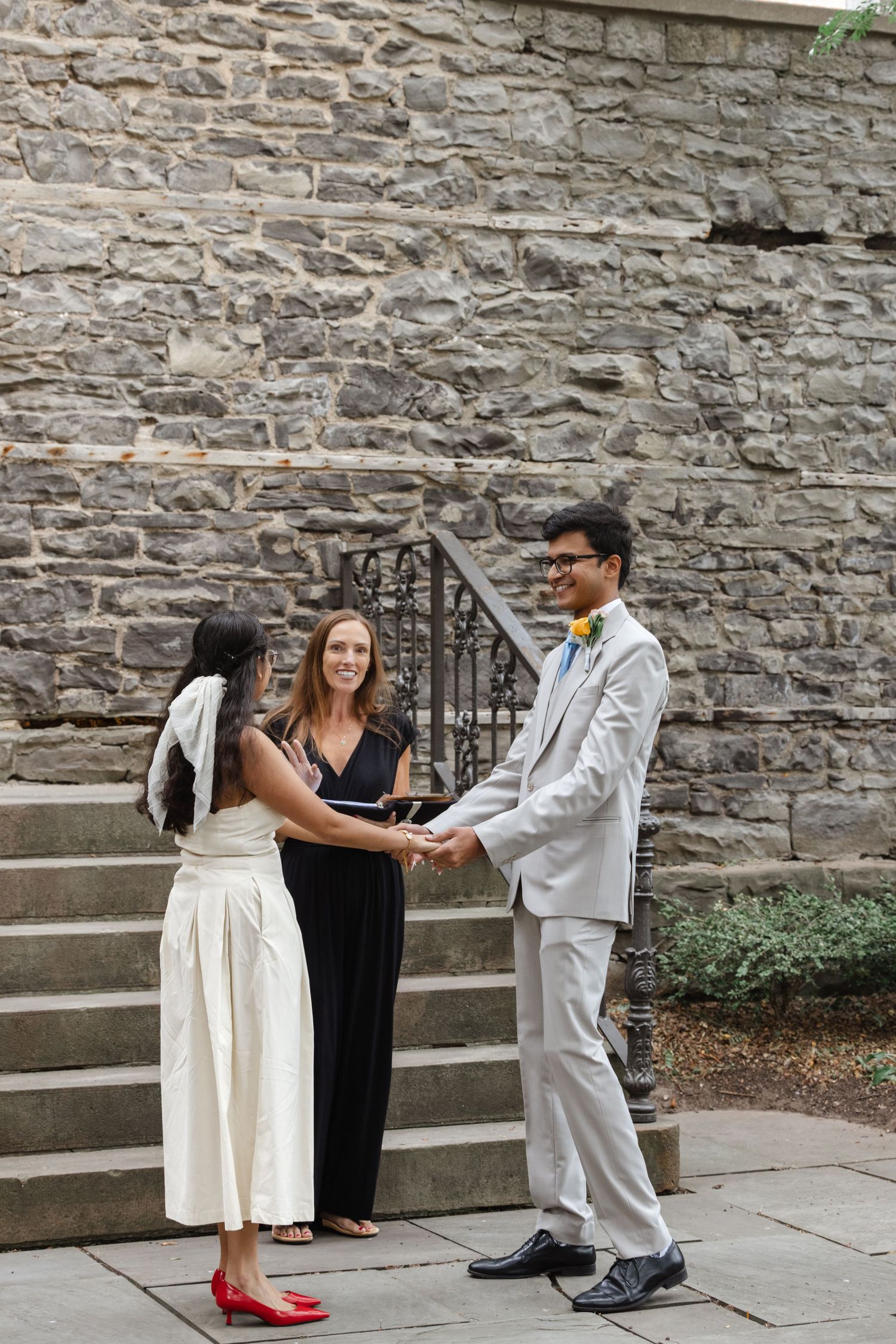 Wedding ceremony taking place on stone steps with stone wall backdrop.  St. Josephs park wedding photographer