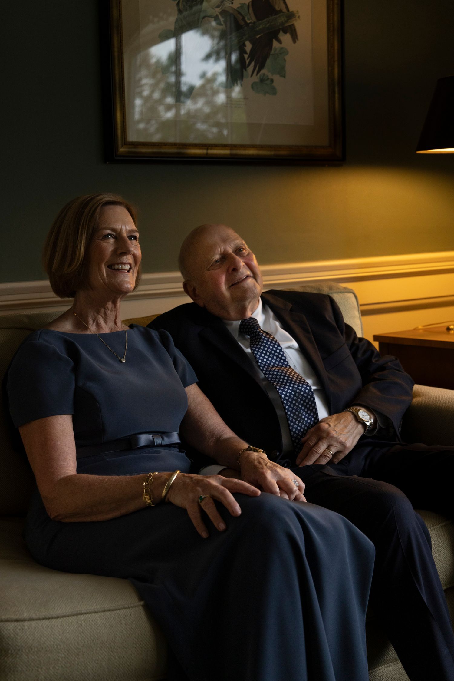 Couple relaxing together on a couch in warm evening light. Film wedding photographer NY