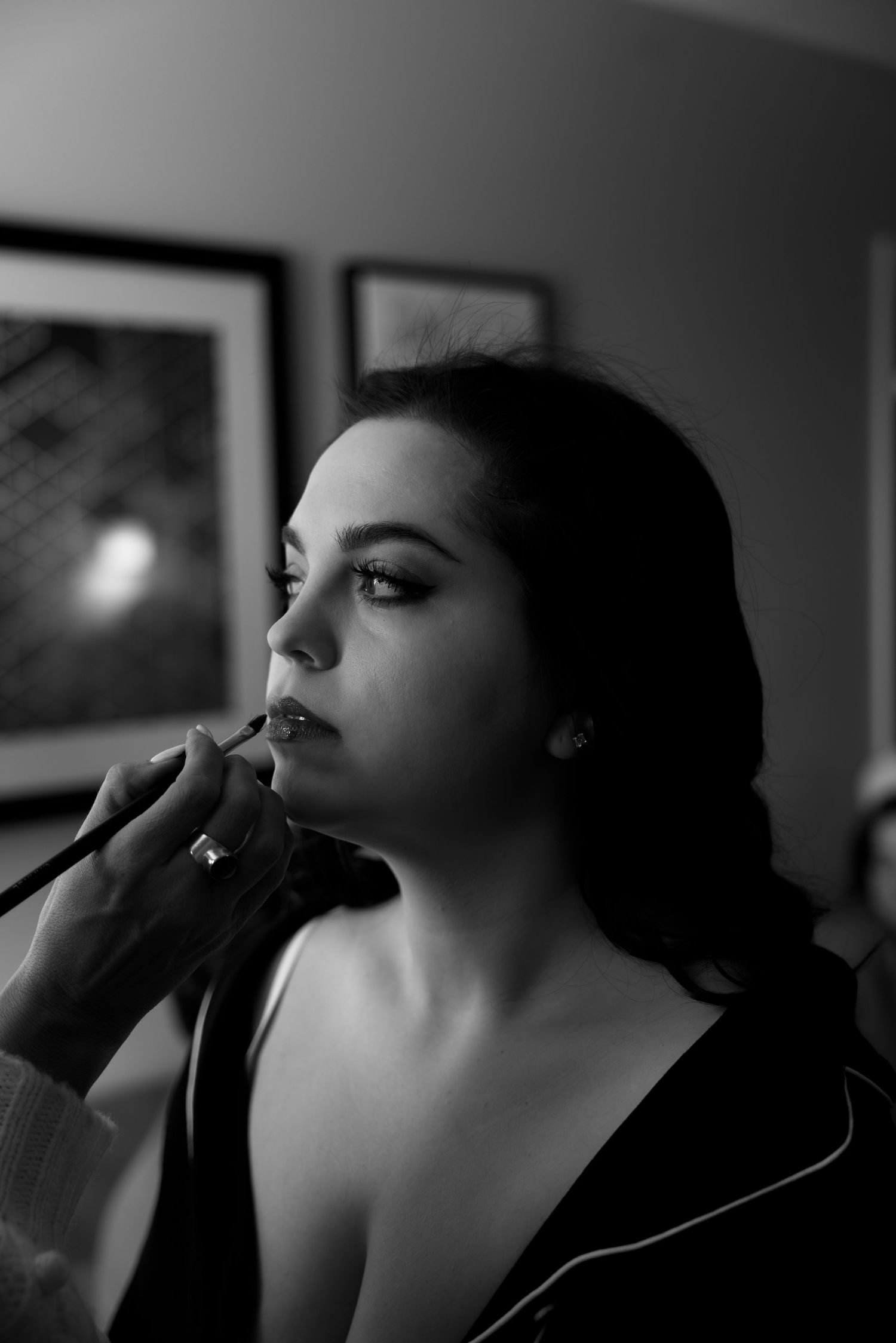 A dramatic black and white photo sequence shows someone applying lipstick in moody lighting.