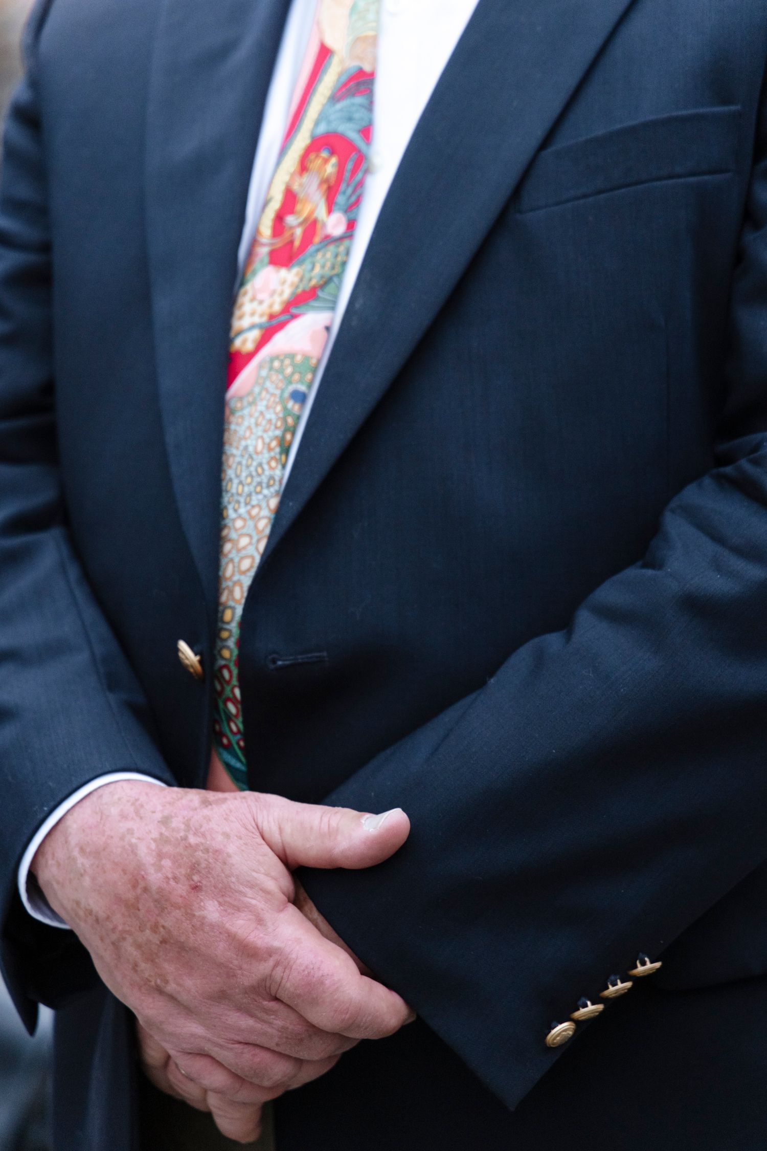 Close-up of a colorful patterned tie against a dark suit jacket. Rochester NY documentary wedding photography