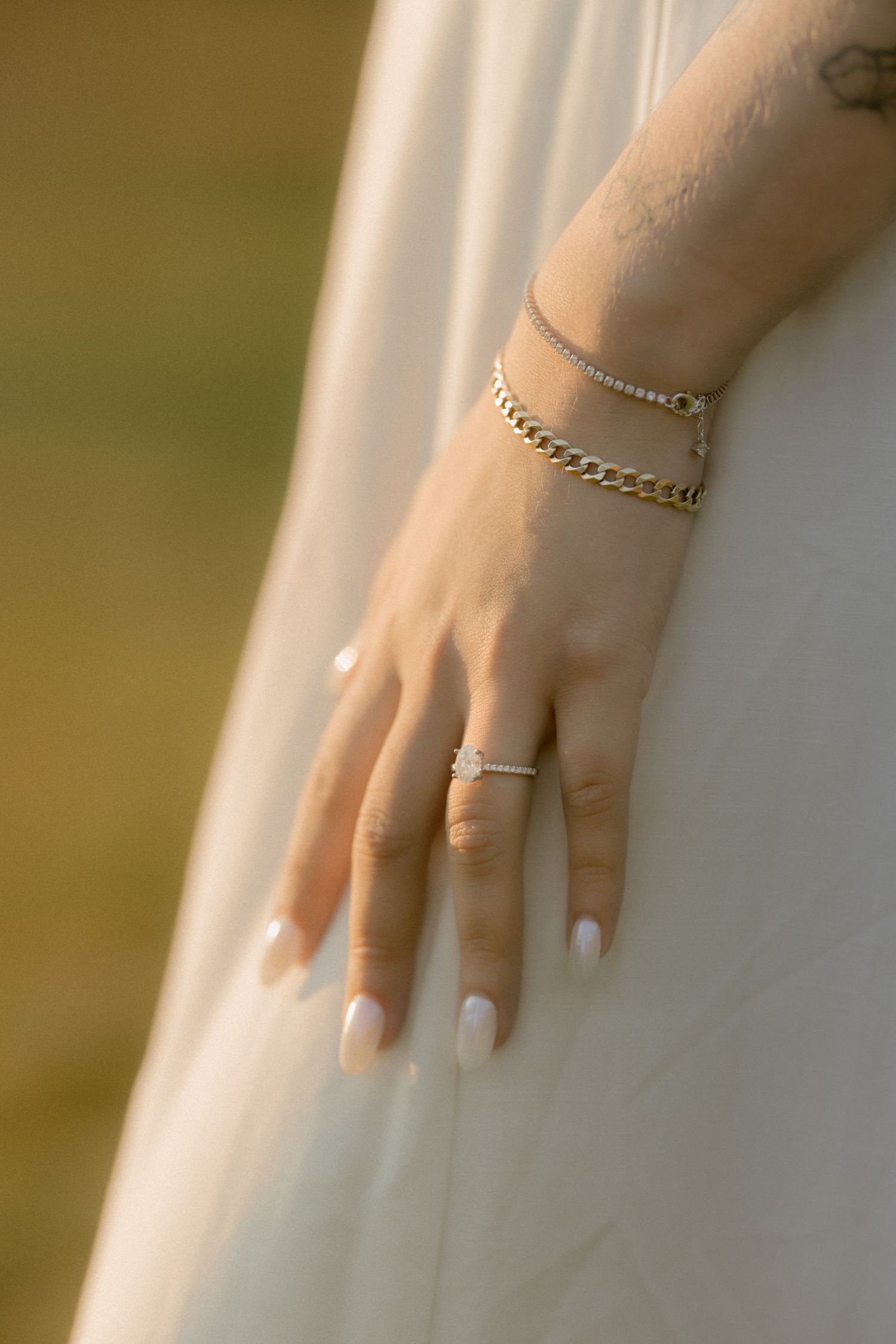 Close-up of delicate jewelry and rings on a hand with white manicured nails. Film wedding photographer Rochester  NY