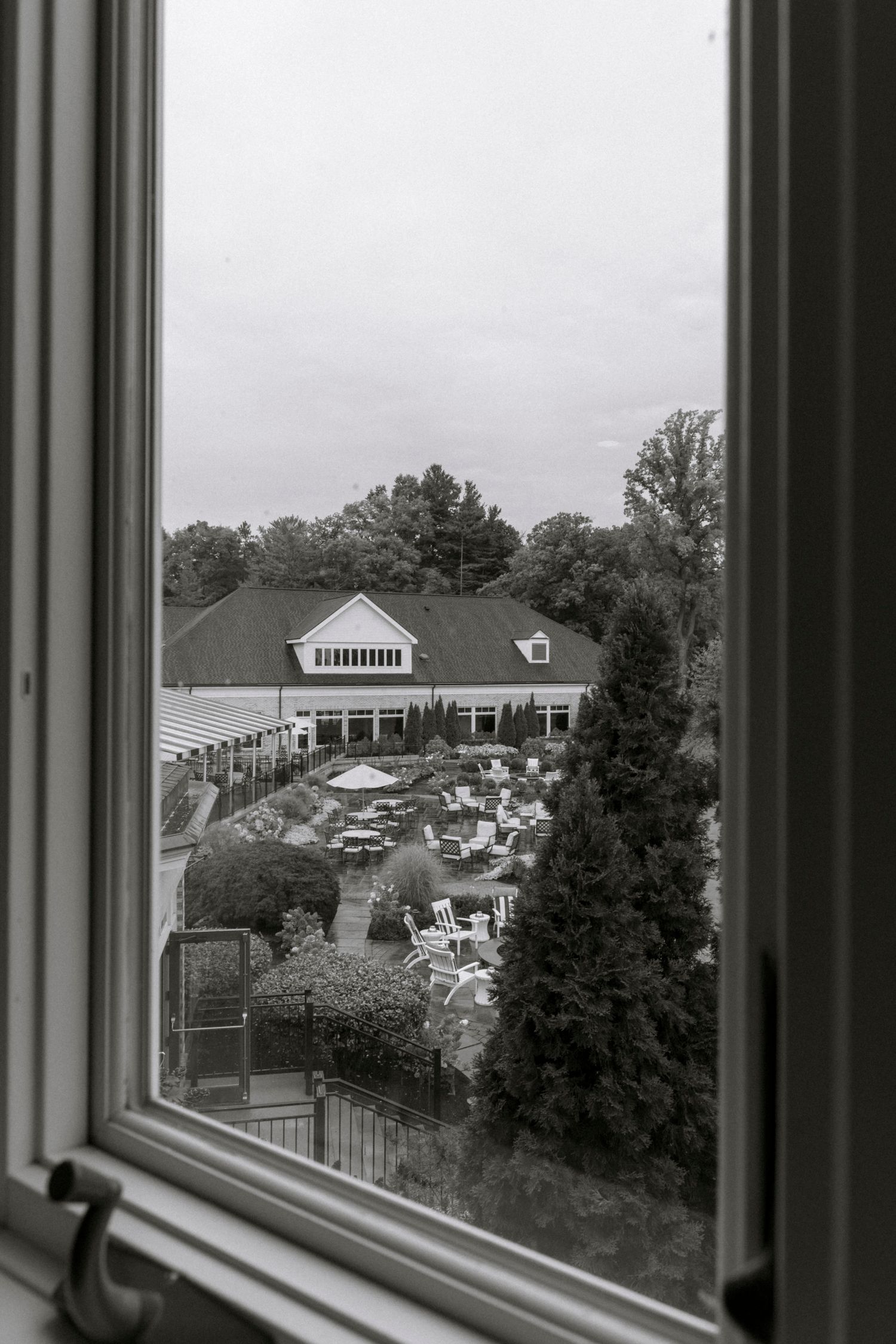 View through a window showing a wedding venue and grounds with white tents in the distance.Rochester NY documentary wedding photography
