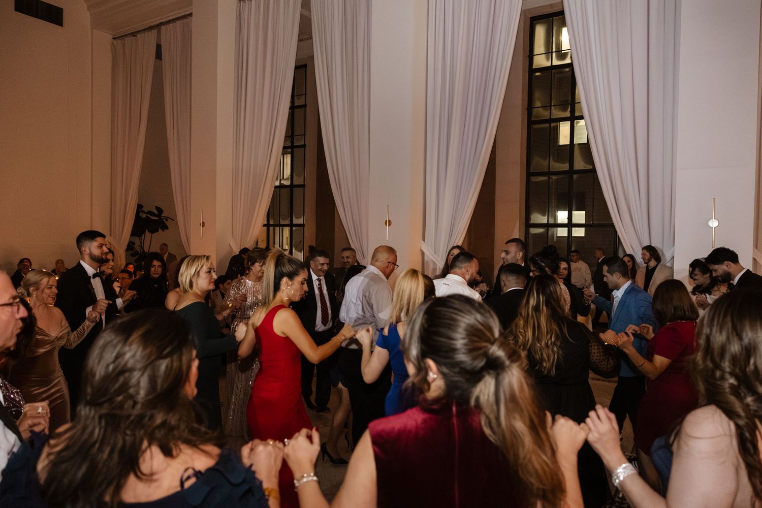 Wedding guests dancing and celebrating on a crowded reception dance floor. Arbor Midtown wedding photographer