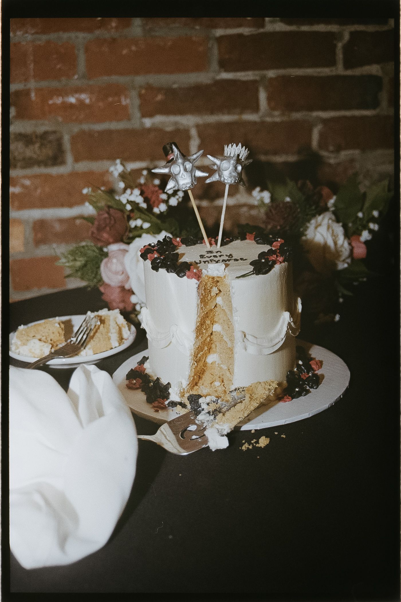 A close-up image of a white wedding cake decorated with flowers and other ornaments.