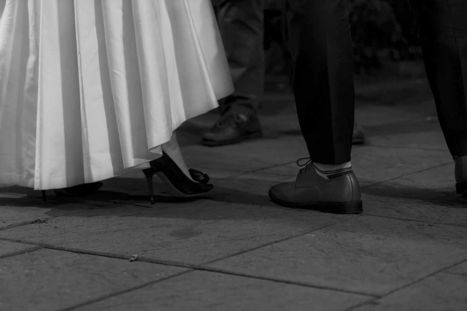 Black and white detail shot of formal dress and shoes on a dance floor. Film wedding photographer Rochester  NY