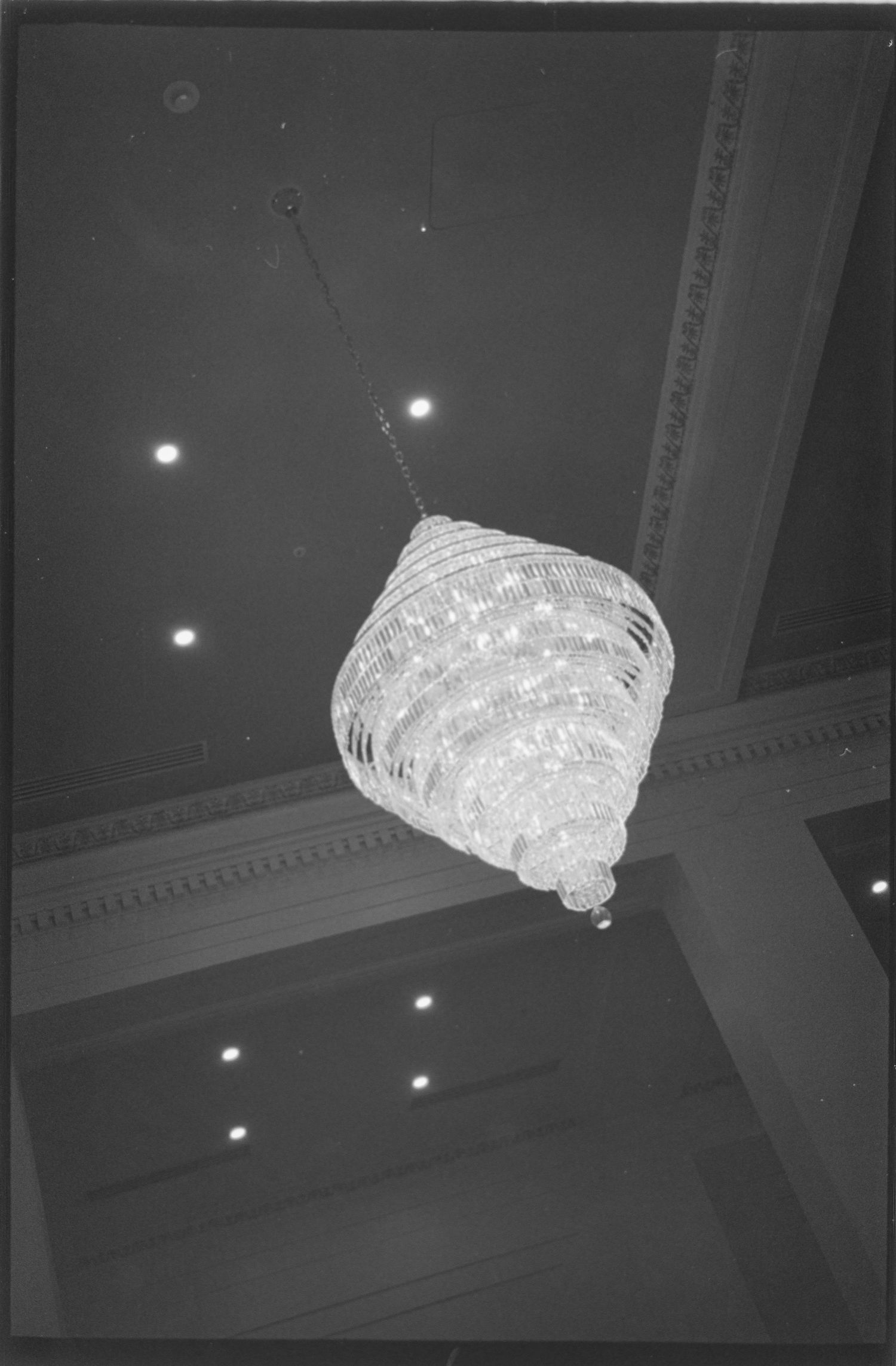 Crystal chandelier hanging from ornate ceiling in an elegant ballroom. Rochester NY film wedding photographer