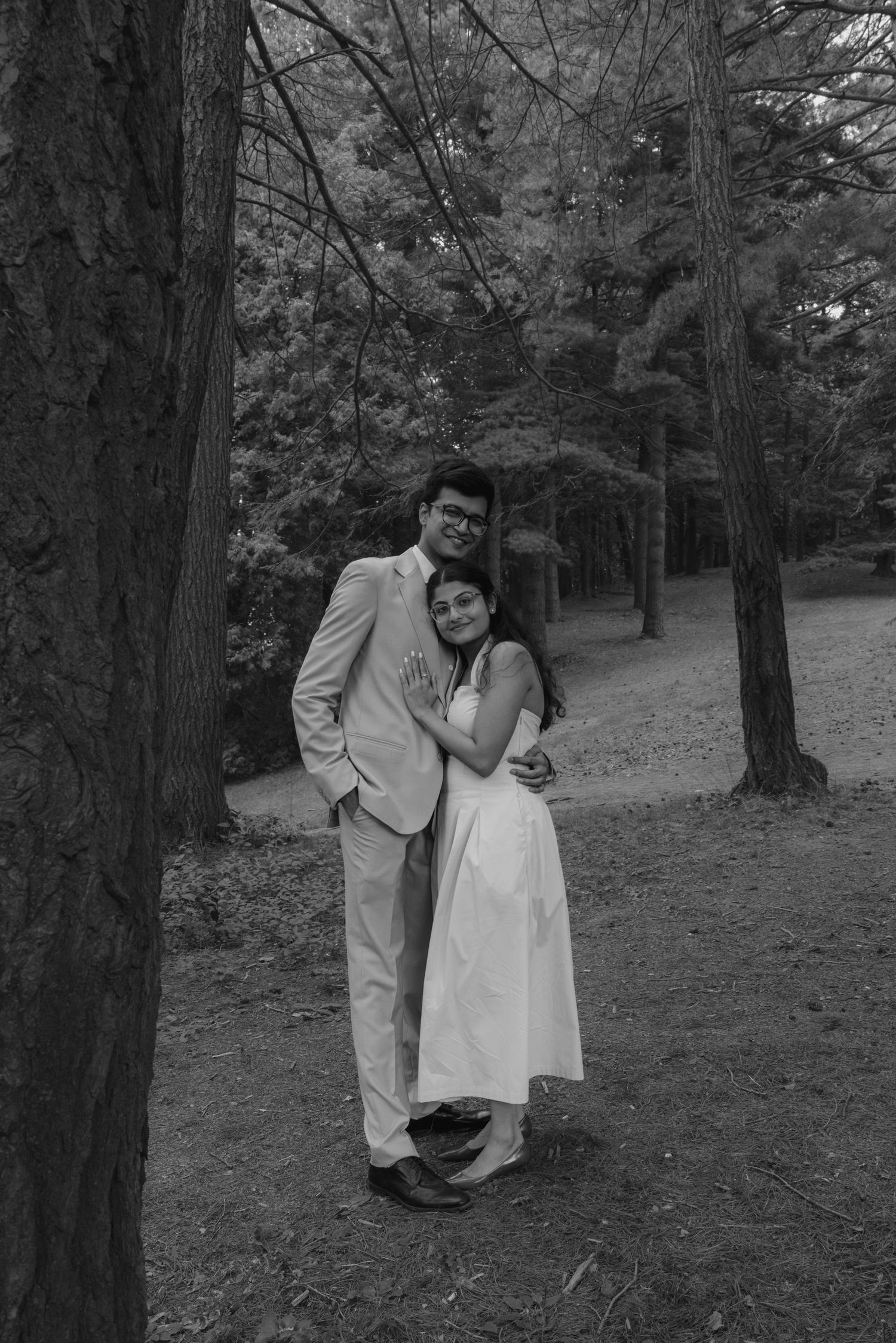 A romantic black and white photo series of a couple embracing in a wooded setting.  Rochester conservatory wedding photographer