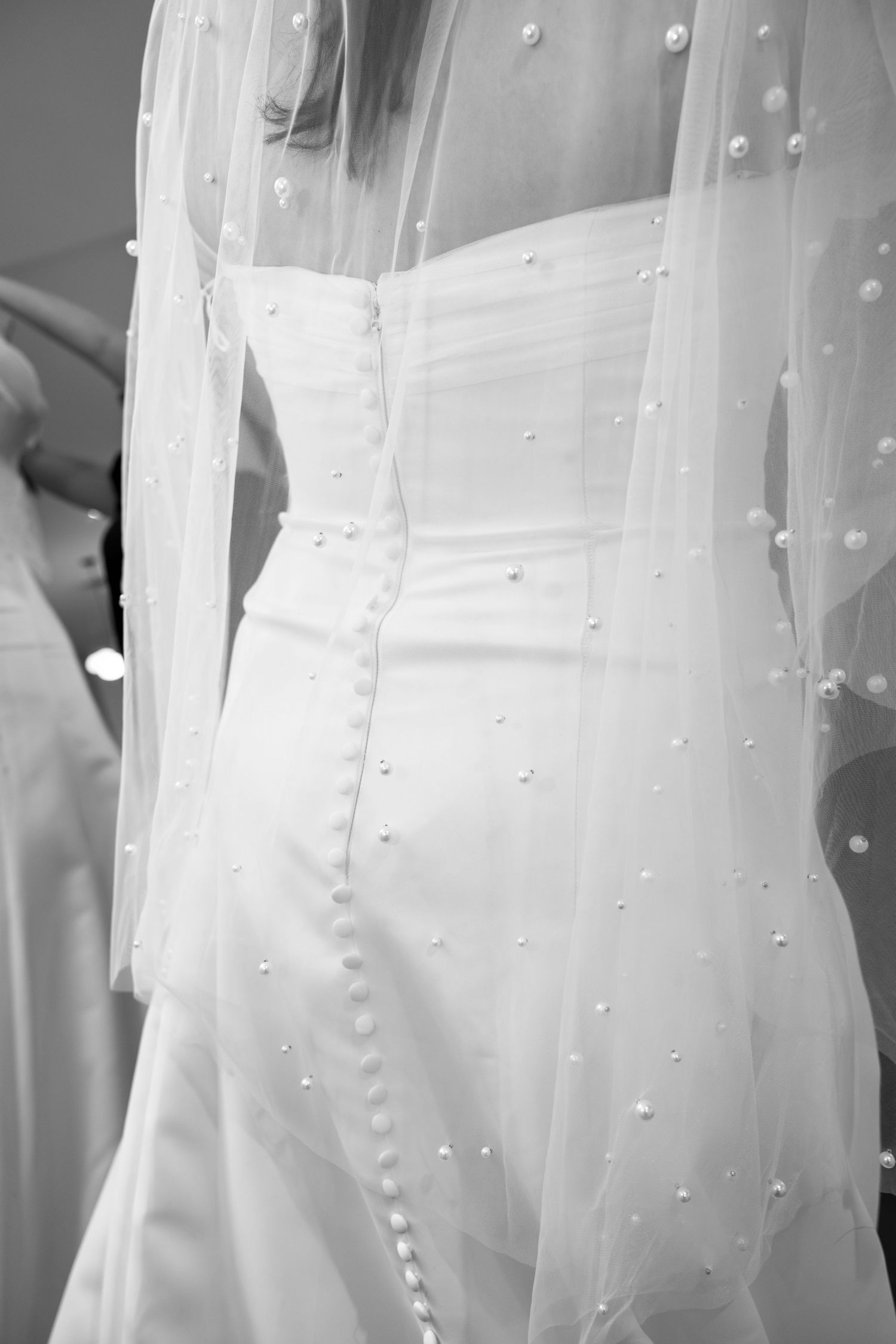 Close-up of wedding dress veil with delicate pearl details.
