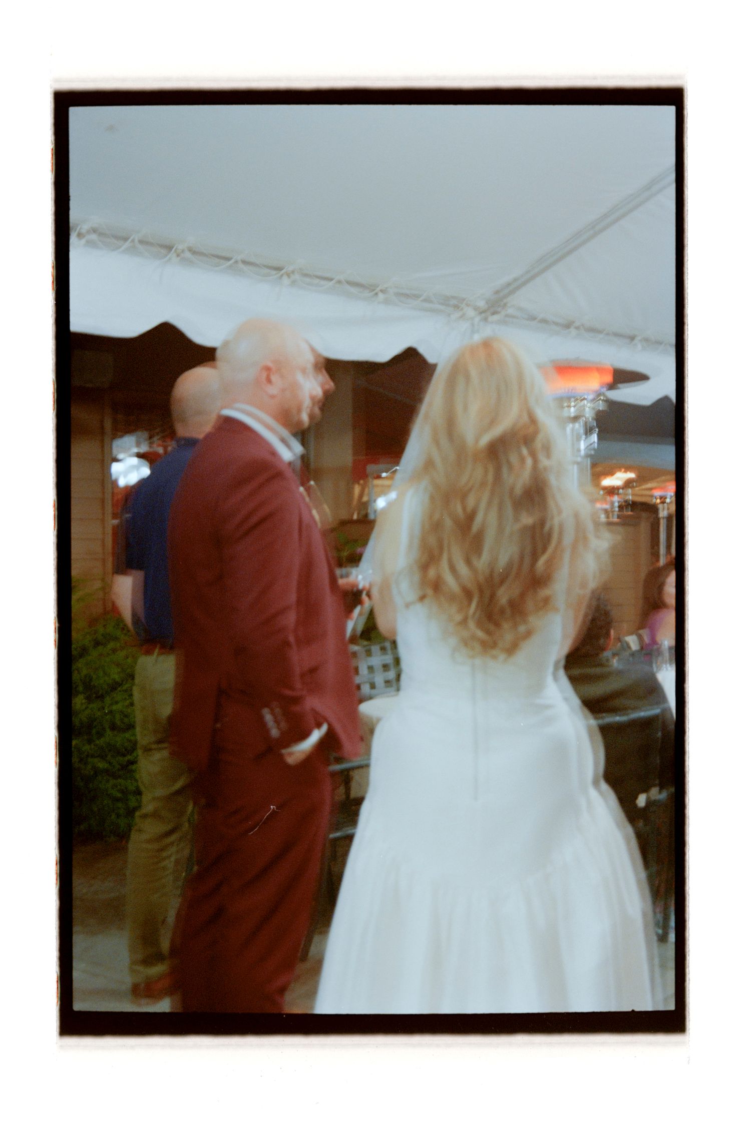 Wedding ceremony scene captured from behind in warm lighting. Rochester NY Film wedding photography