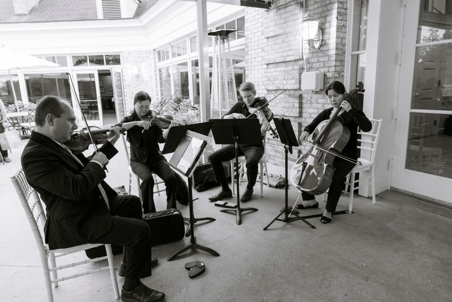 Musicians with instruments perform outdoors at an event.Rochester NY documentary wedding photography