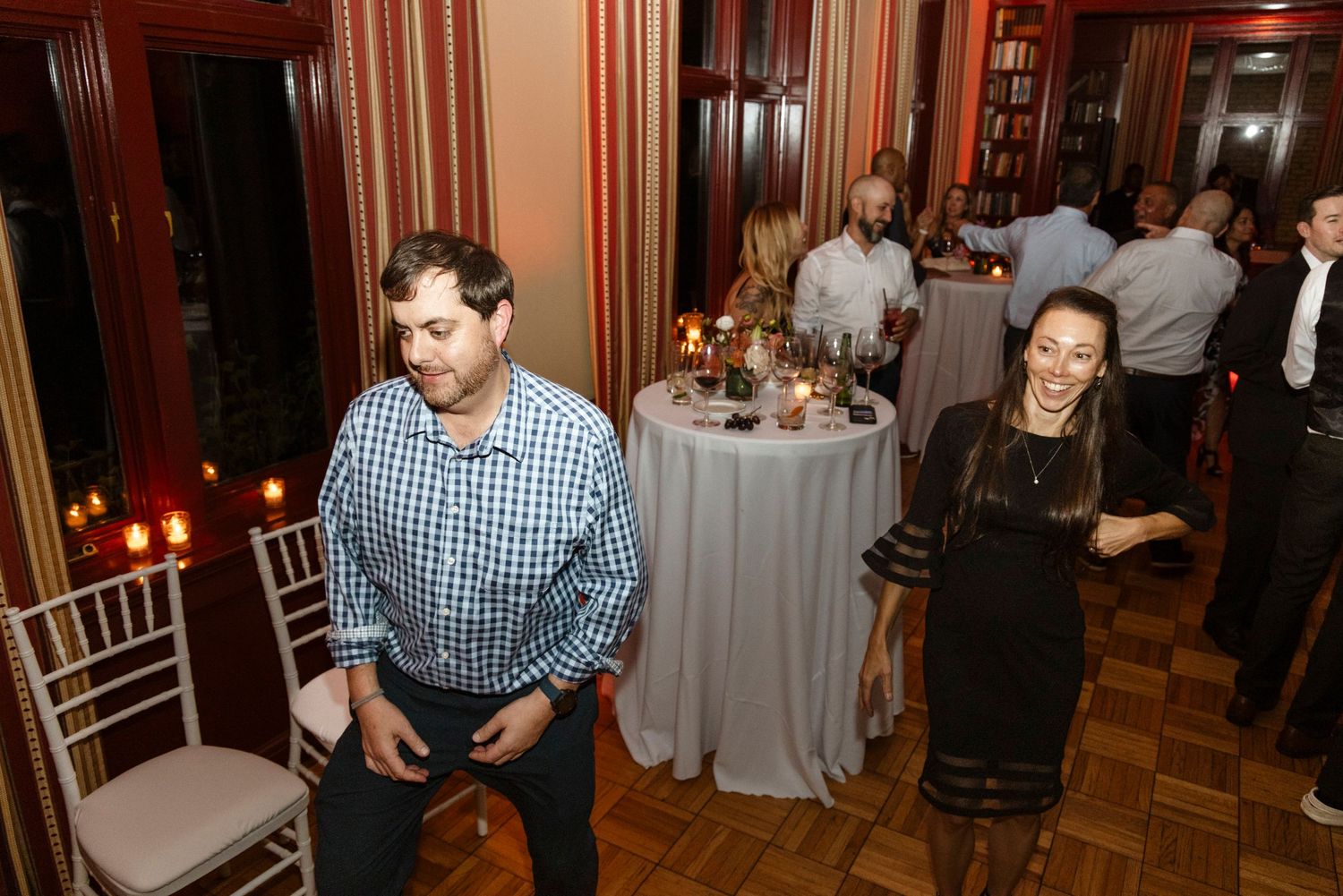 Wedding guests enjoying themselves on a dance floor with elegant decor and lighting. Rochester NY candid wedding photography