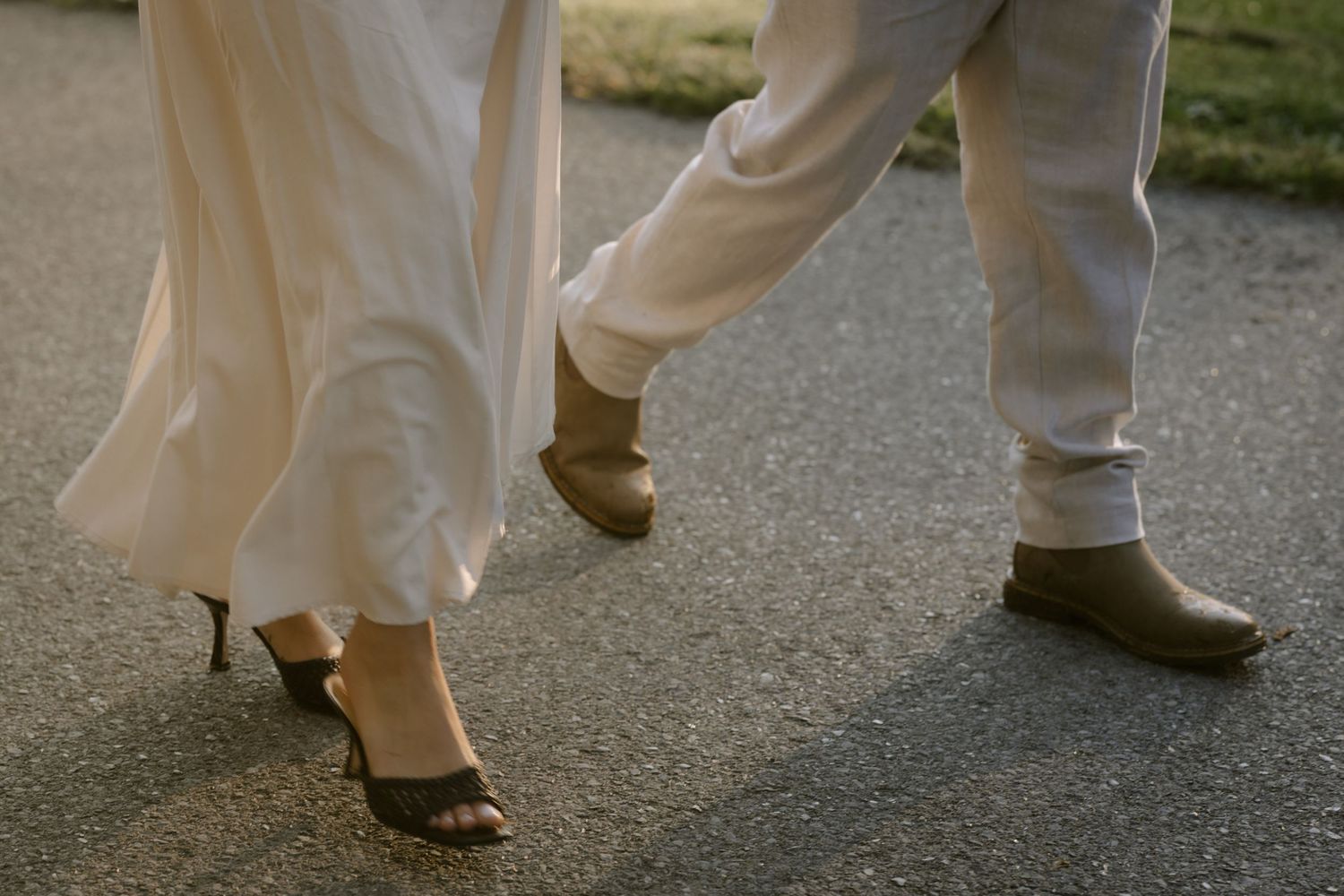 Close-up of white clothing and shoes walking on pavement during an outdoor photo session. Rochester NY authentic engagement photography