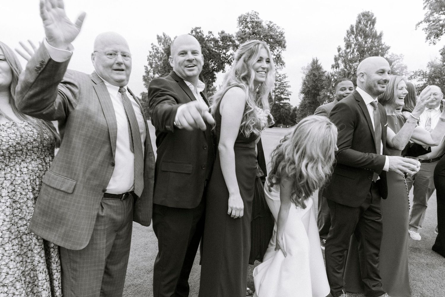 Wedding guests gathered outdoors in formal attire. Film wedding photographer NY