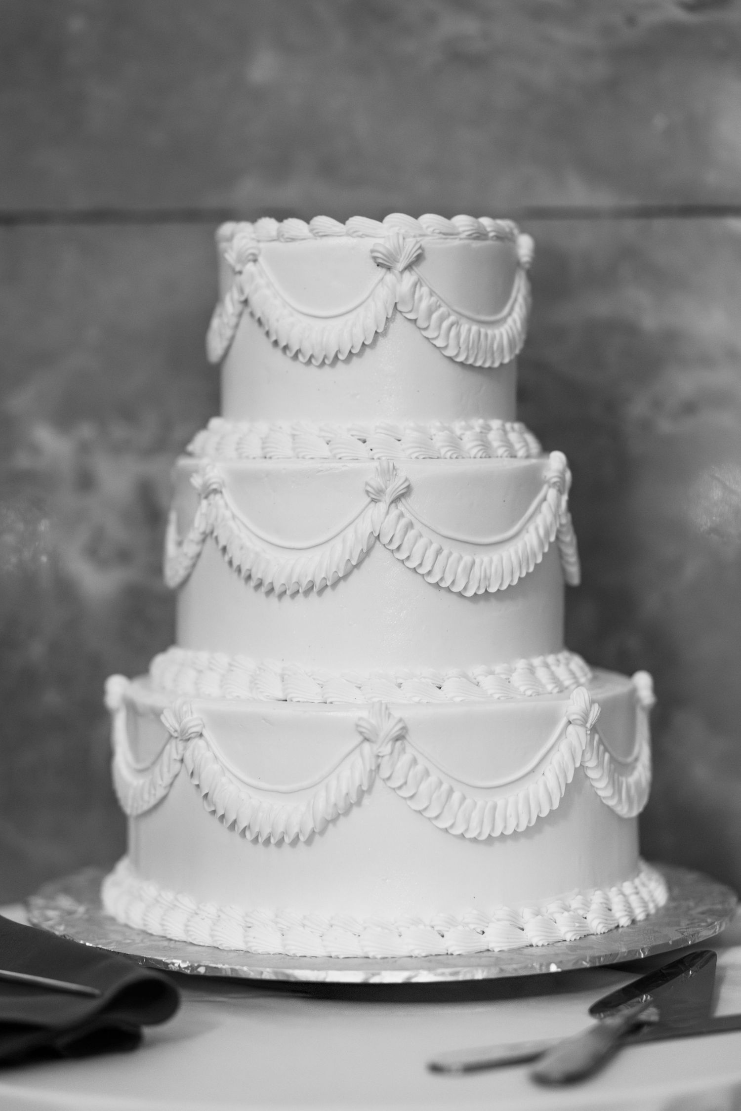 Classic white wedding cake with traditional piped frosting details and scalloped design. Arbor Midtown wedding photographer