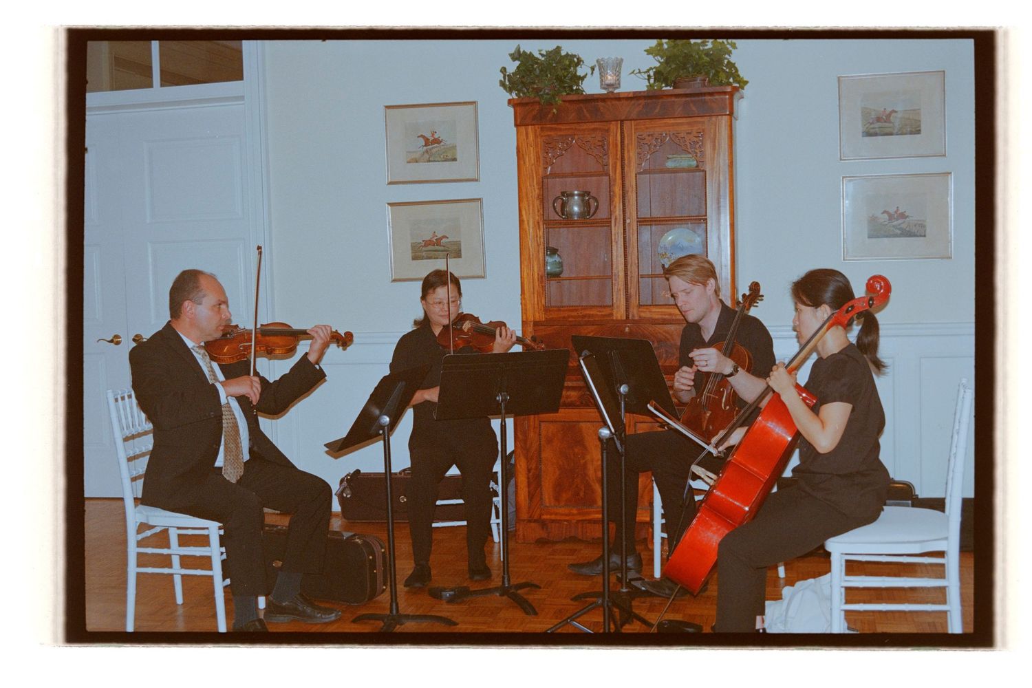 String ensemble performing classical music in a formal indoor setting. Rochester NY Film wedding photography