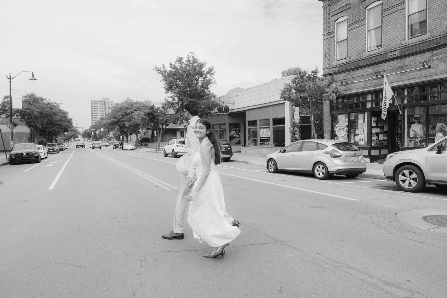 A sequence of urban street scenes with storefronts and parked cars along a sidewalk. South Wedge wedding