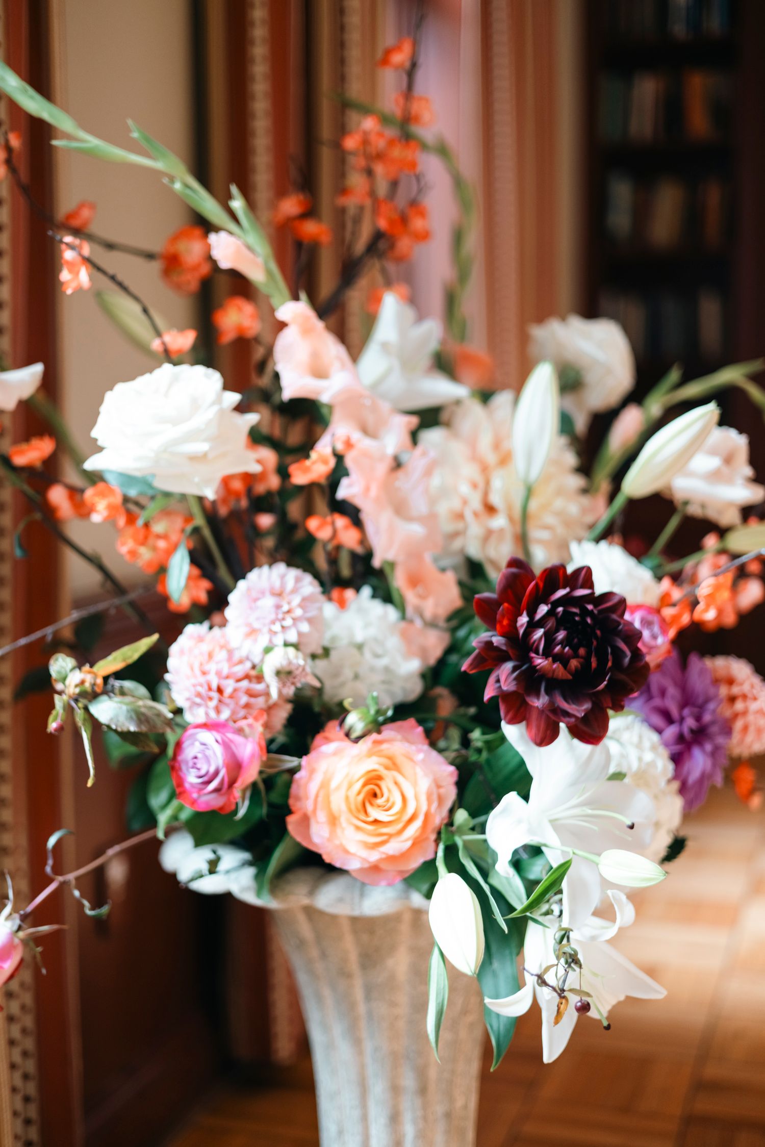Elegant floral arrangement with pink, peach and white flowers in a decorative vase.Rochester NY documentary wedding photography