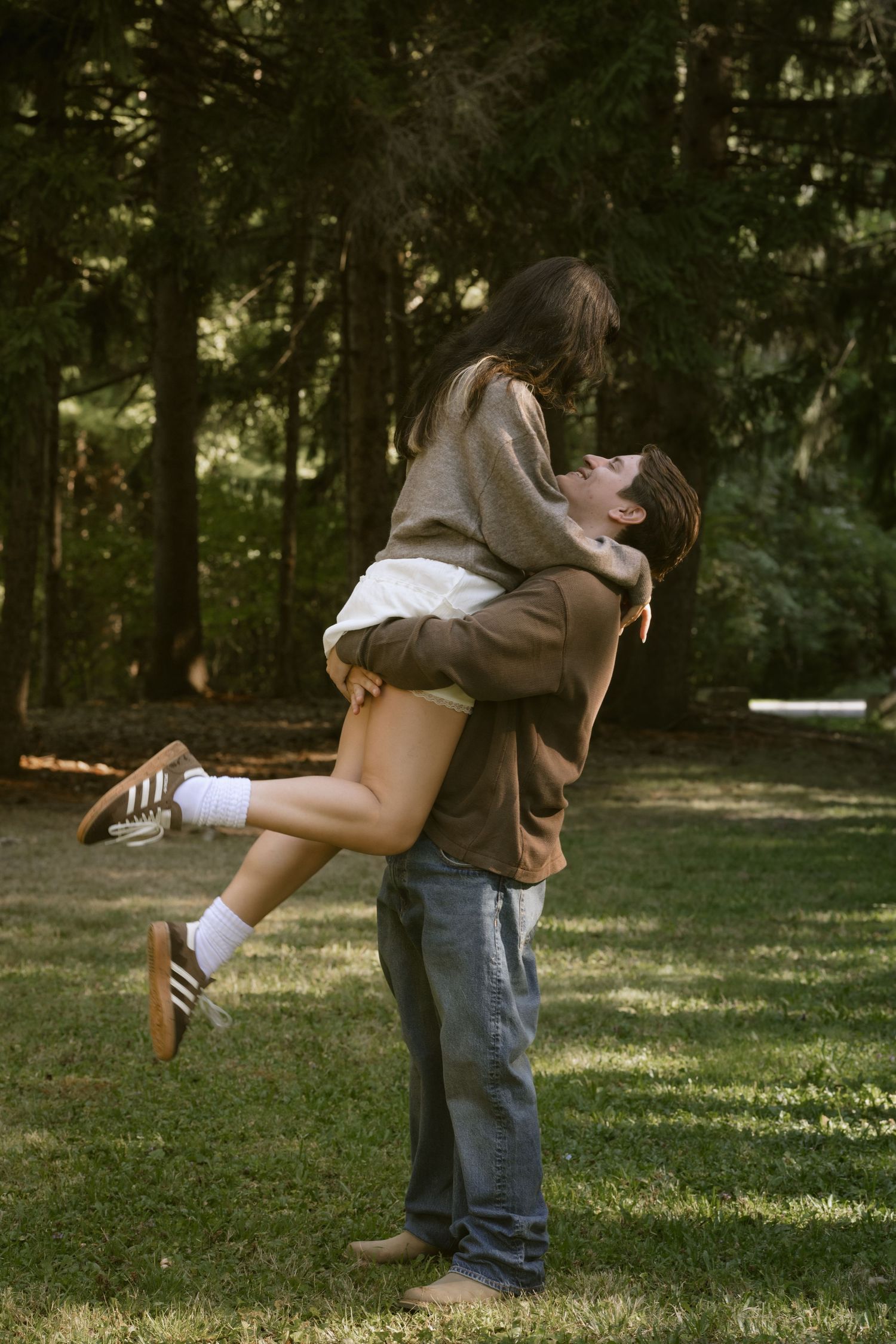 Two people share a romantic dip while dancing in a park setting. Rochester NY documentary engagement photography