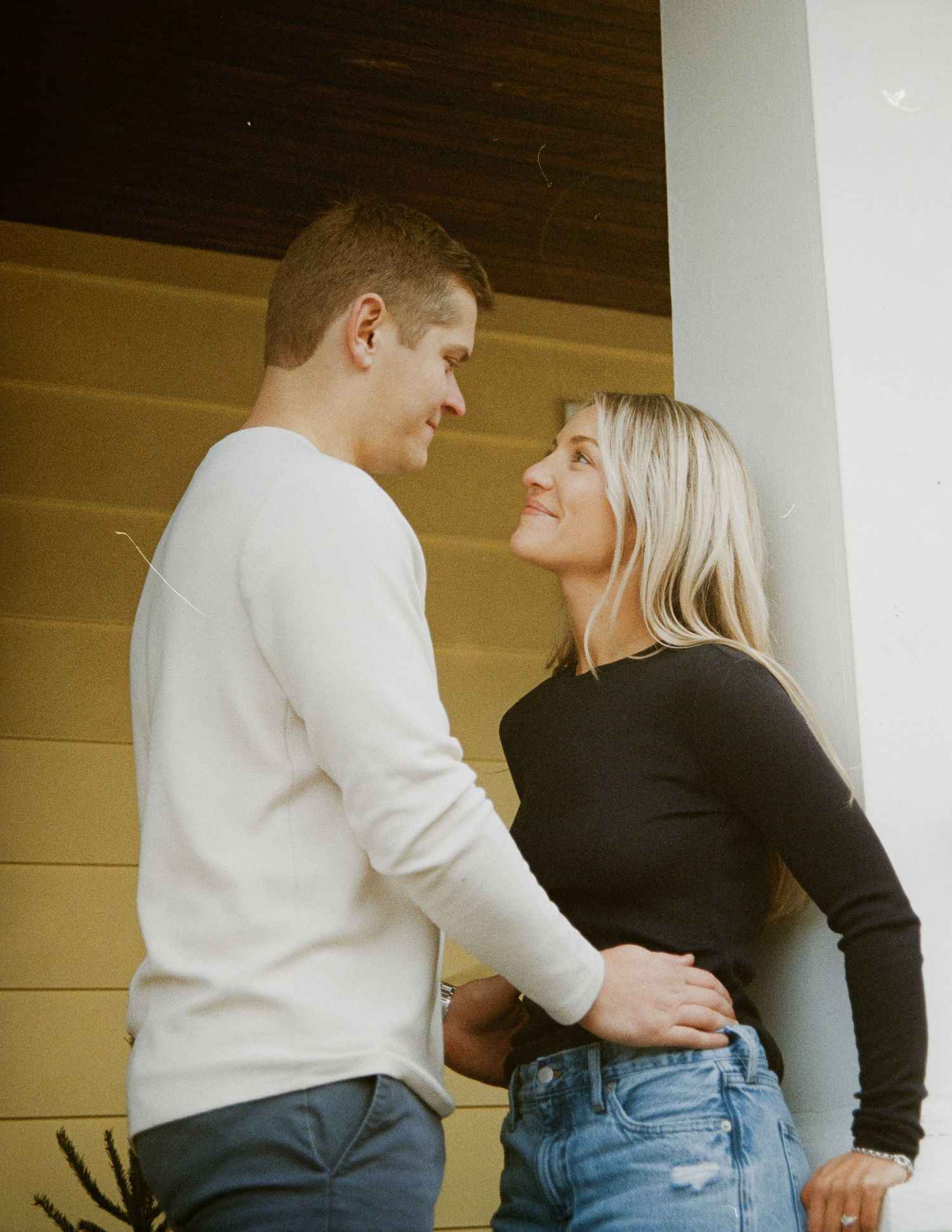 A romantic couple shares an intimate moment on their front porch. Rochester NY engagement photographer
