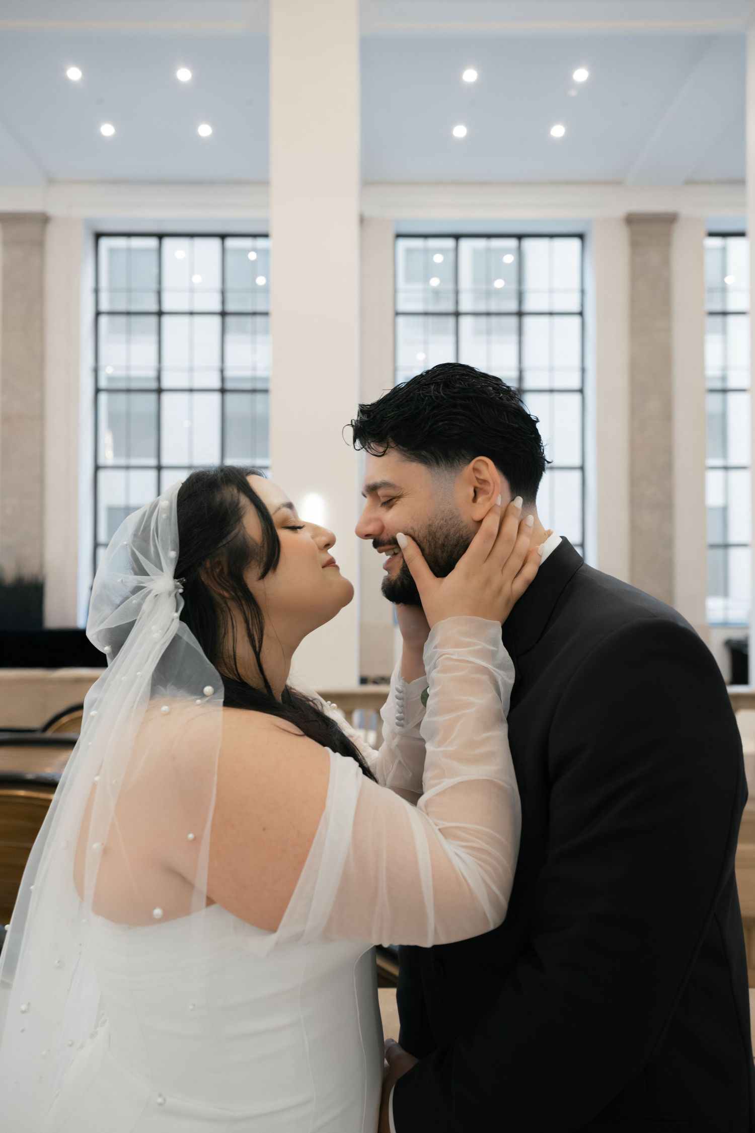 Romantic wedding portraits in a bright room with large windows showing tender moments between newlyweds. Arbor Midtown wedding photographer