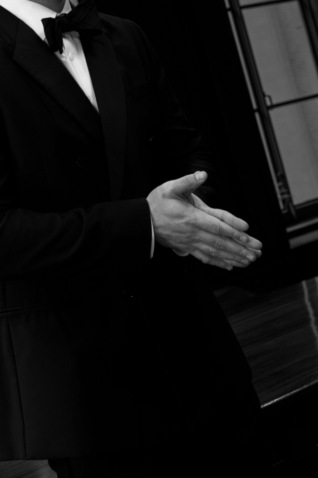 Formal black suit details shown in dramatic black and white photography.