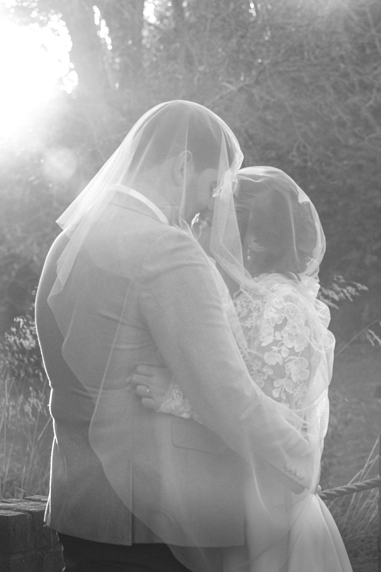 black and white backlit picture of newly married couple