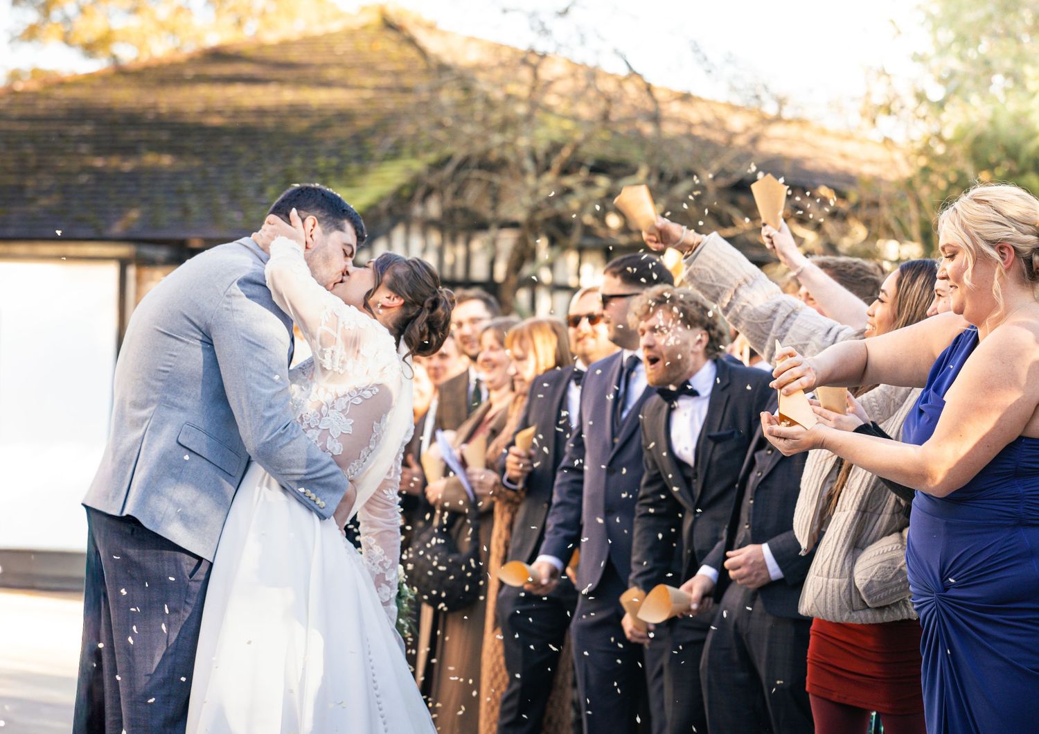 A romantic moment of Bride and Groom sharing a kiss in a confetti moment