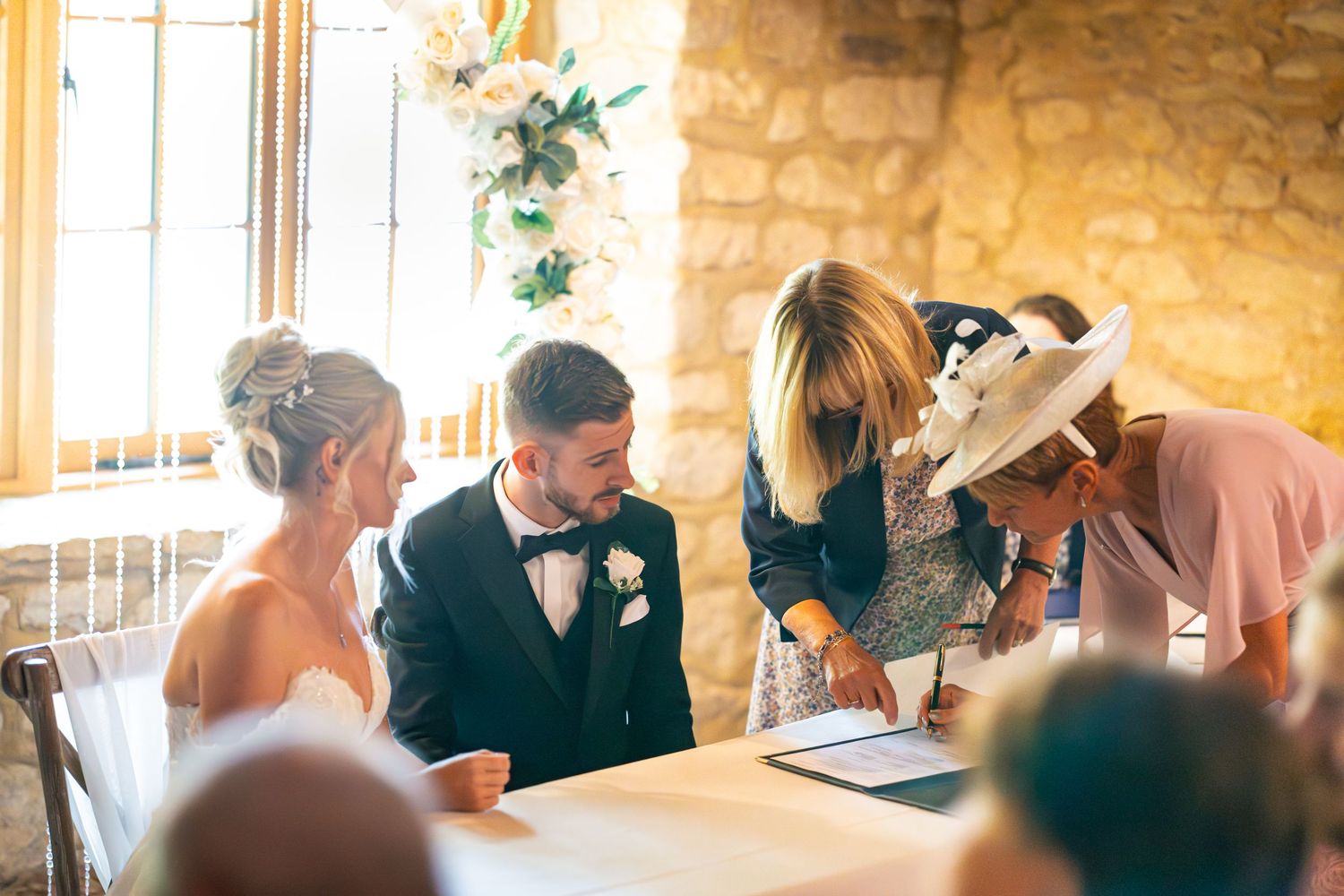 Bride and Groom with witnesses signing the registry book in barn-style wedding