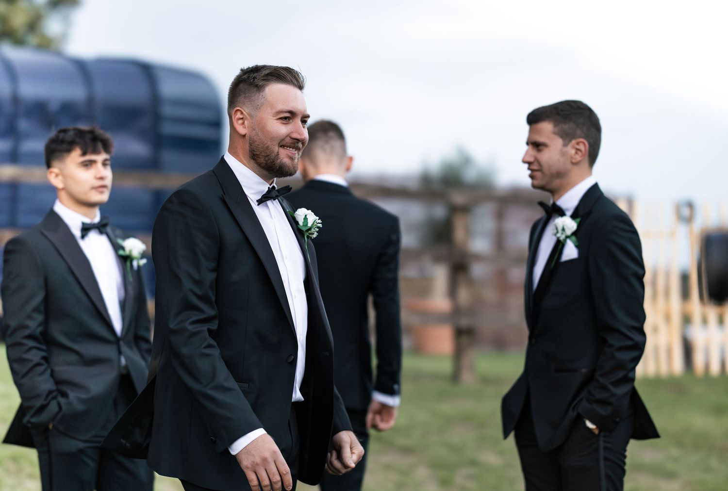 Candid moment of groomsmen relaxed before group pictures