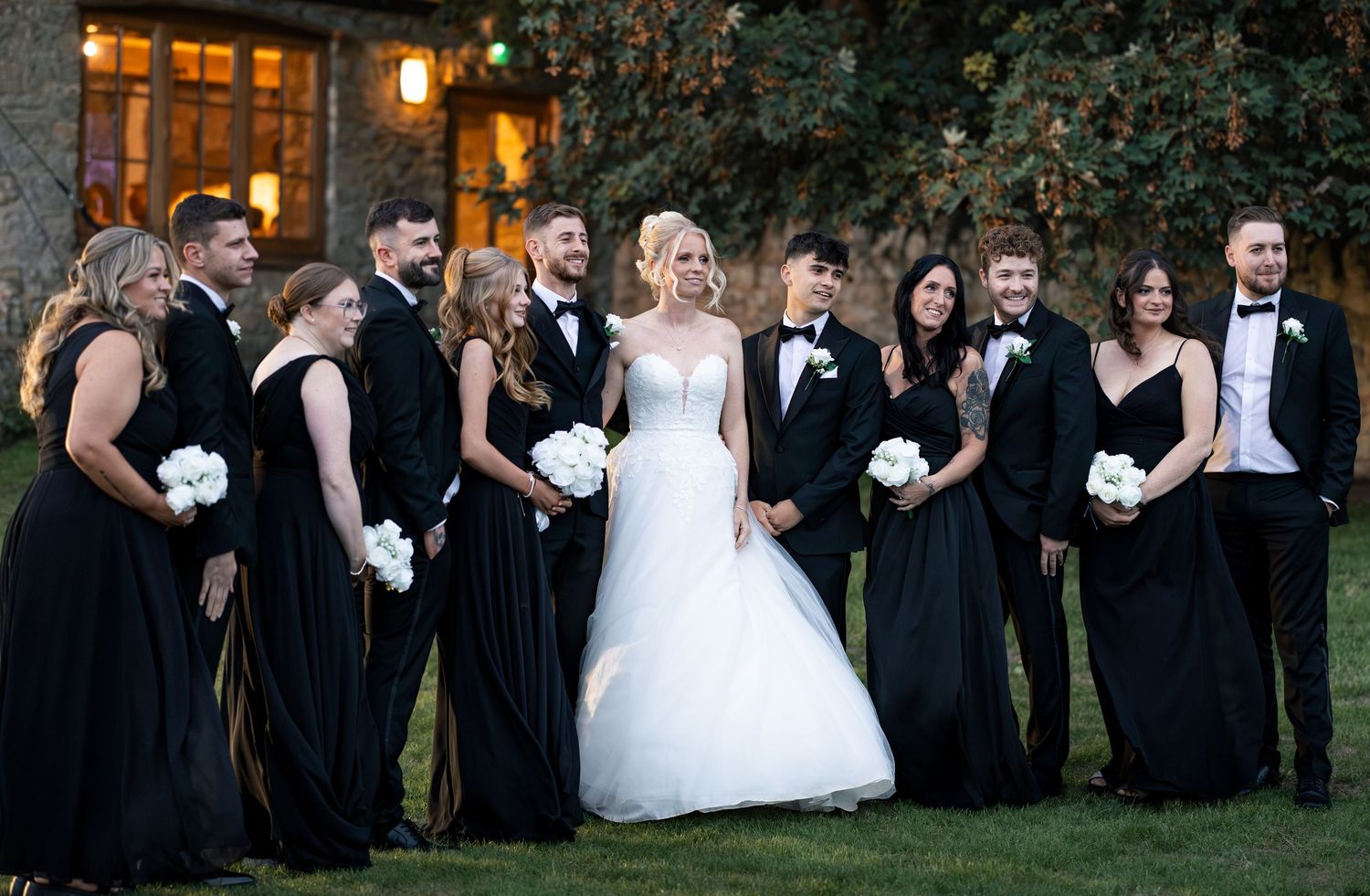 A mixed wedding party posed on the lawn
