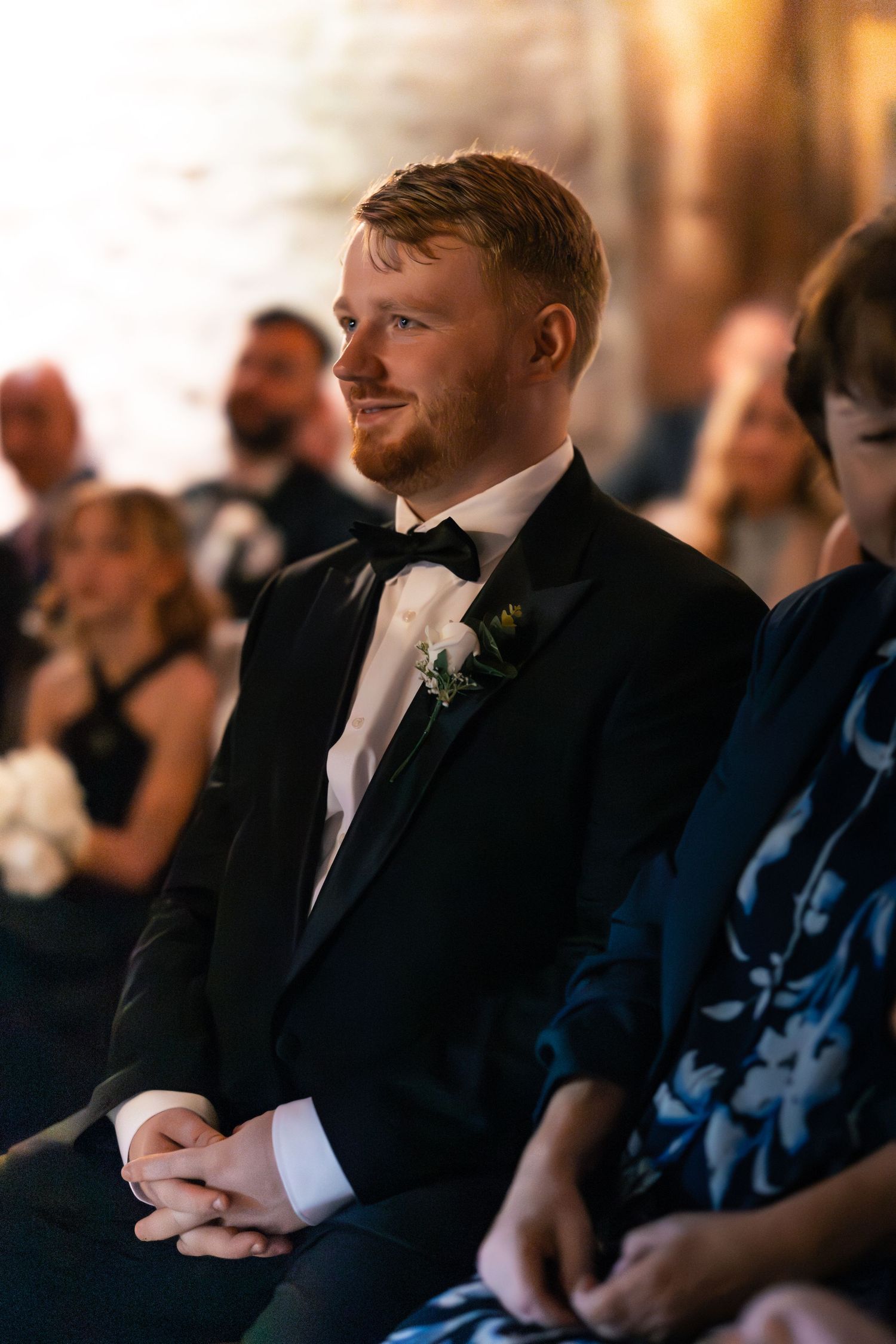 Brother of the bride in tuxedo watching wedding ceremony