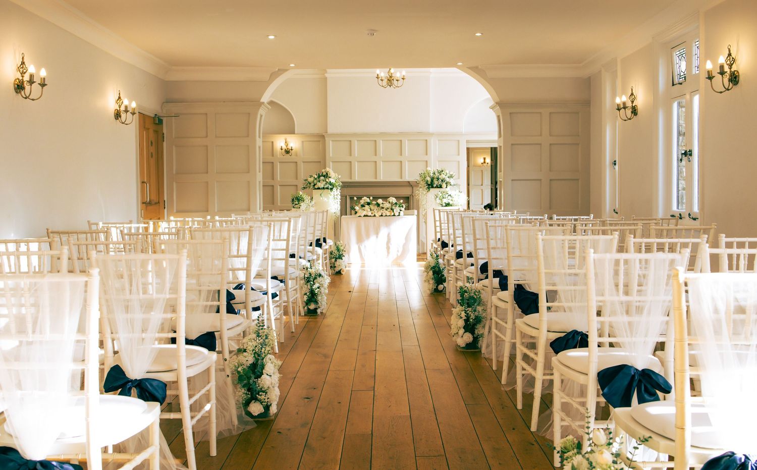 Wedding ceremony room with navy blue chair ties.