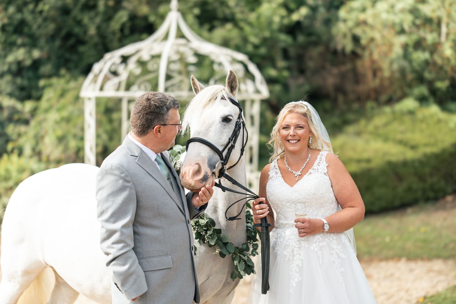 Bride and Groom share a picture with their white horse